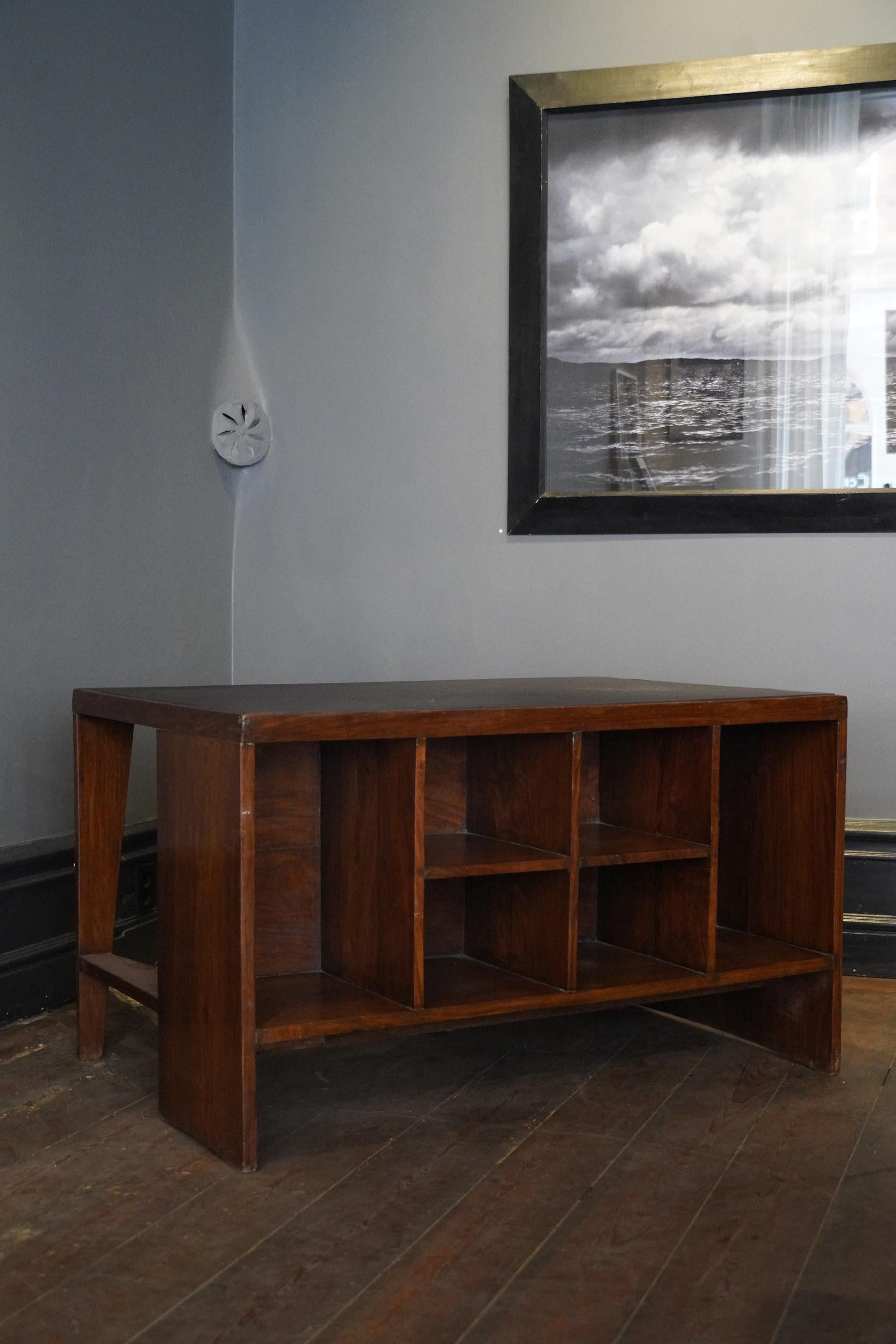 Dieser original Pierre Jeanneret PJ-BU-02-A Pigeonhole-Schreibtisch aus Teakholz stammt von der Designlegende Pierre Jeanneret.  Schwarzes, neu bezogenes Lederoberteil. Eine einzelne Schublade und ein offenes Schubladenregal.

Jeanneret wurde von