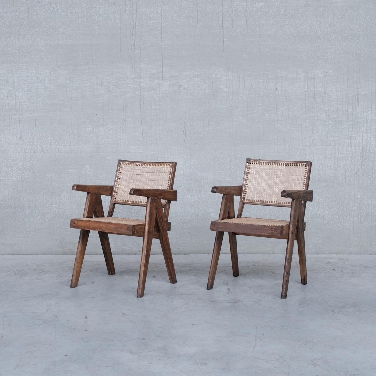 A pair of increasingly scarce original Pierre Jeanneret armchair desk chairs. 

A flexible chair that can be used at tables or as bedroom chairs or lounge chairs. 

India, Chandigarh, c1955s. 

Model PJ-SI-28-B. 

Teak and cane. The cane has