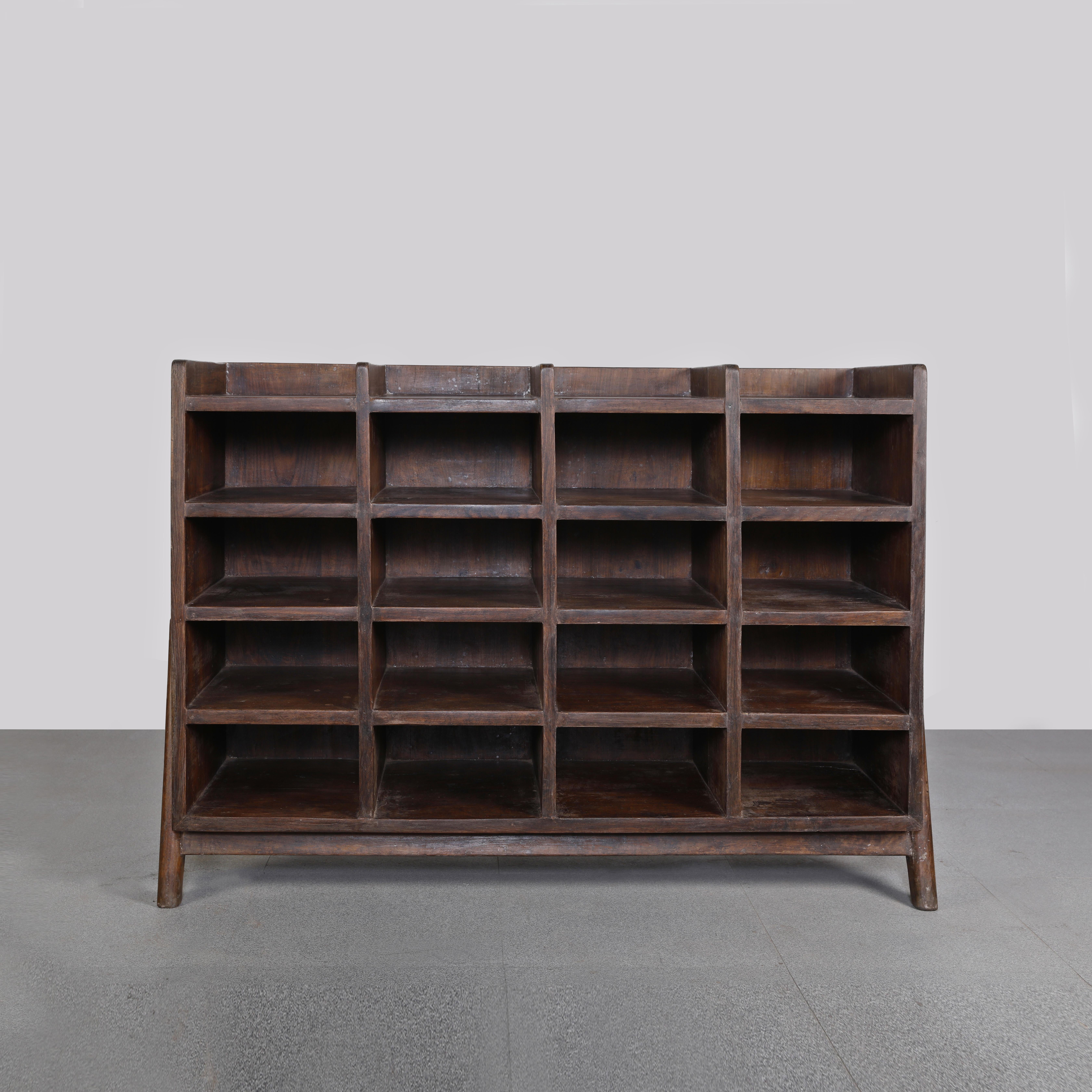 This storage unit with 20 holes is very rare and fantastic piece of solid and elegant piece of furniture in the same time. It is raw in its simplicity of construction. The characteristic legs, combined with the warmth of the solid teak wood make it