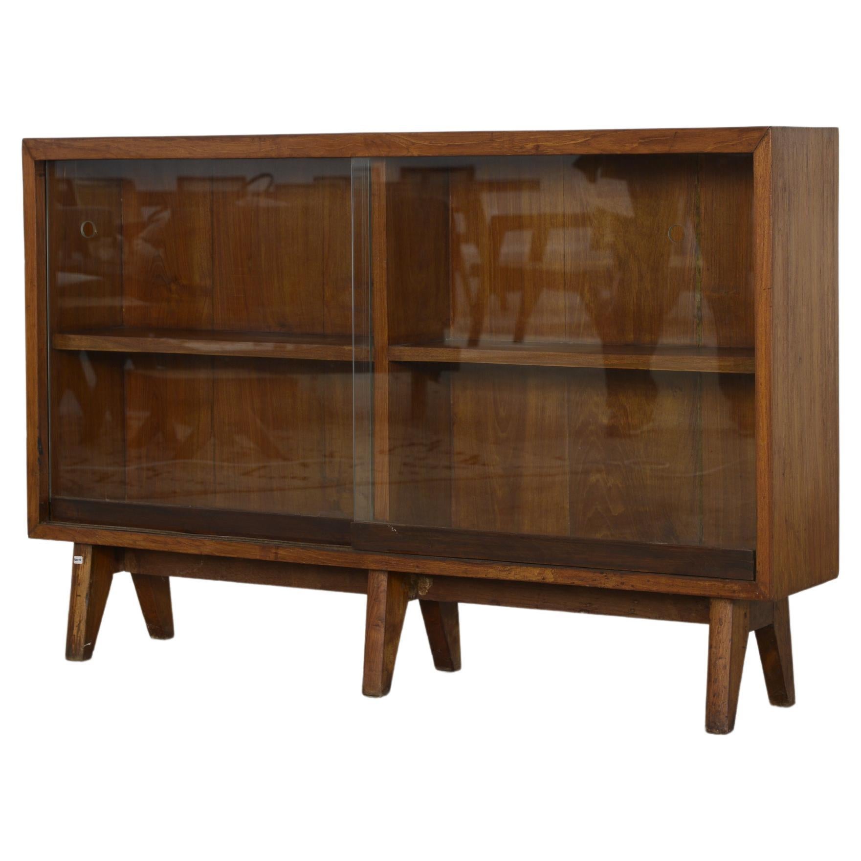 This glass-fronted bookcase is an iconic design piece. It is raw in its simplicity it shows a slightly patinated material. It's shape is beautifully fragile and has a wonderful color. We don't restore them too much. So we keep as much as possible of