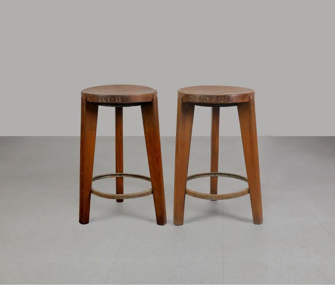 A pair of round stools with wood seats from ca. 1965-1966. All wooden parts are authentic. They have authentic written letters on the side which makes this set even more valuable. 
The round top done in massive wood. The 3 legs are holding the top