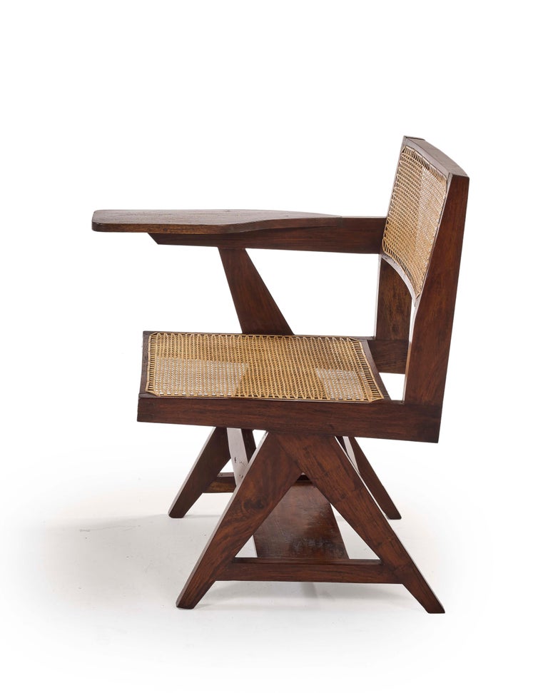 Pierre Jeanneret
Writing chair, circa 1960 
PJ-SI-26-A
Solid teak.
Version with right leg in inversed “Y” which support a tablet. Solid teak, cane.
Tablet under seat.
Provenance : Punjab University, Chandigarh, India
A model is in the