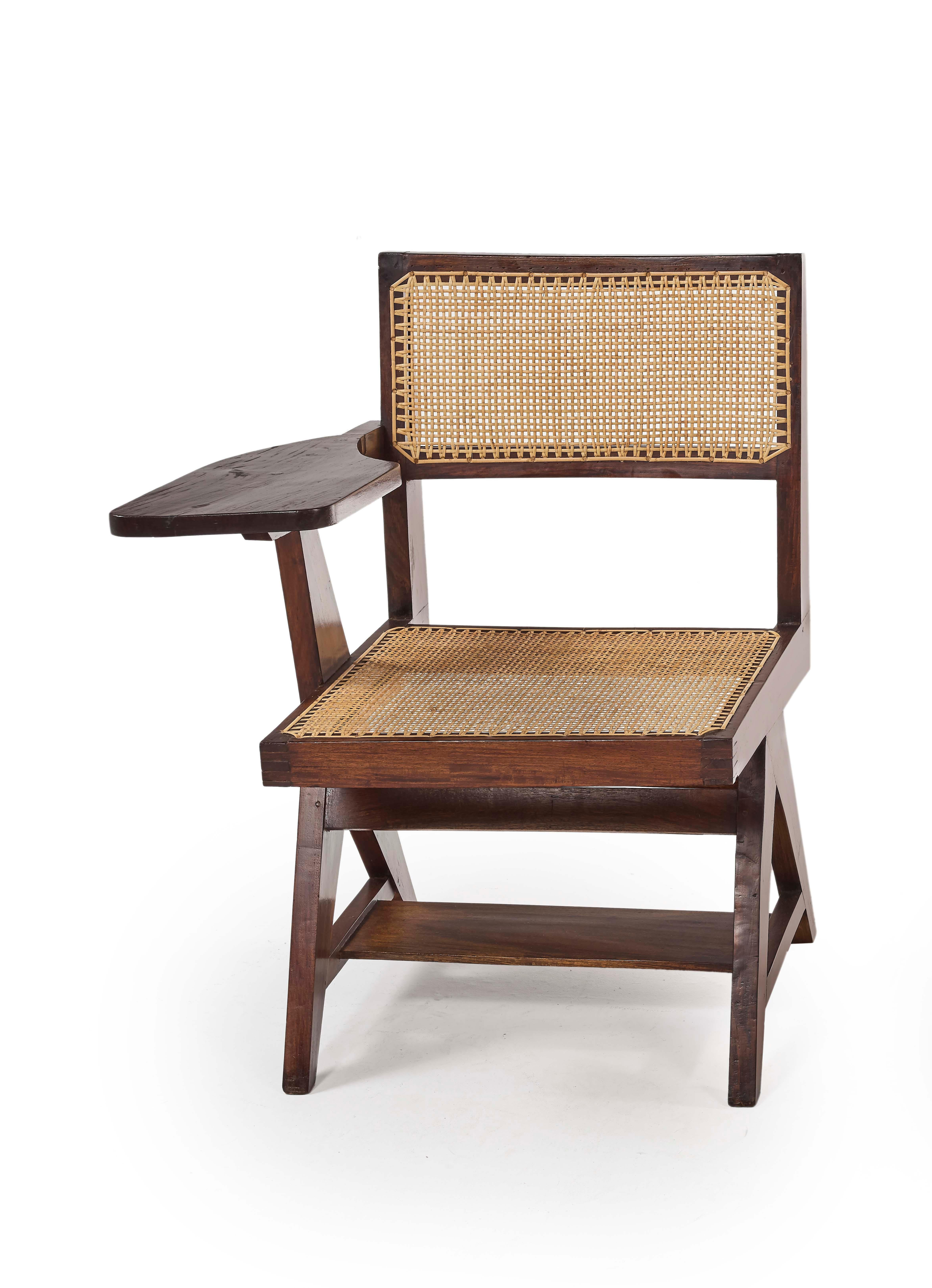 Pierre Jeanneret
Writing chair, circa 1960 
PJ-SI-26-A
Solid teak.
Version with right leg in inversed “Y” which support a tablet. Solid teak, cane.
Tablet under seat.
Provenance : Punjab University, Chandigarh, India
A model is in the