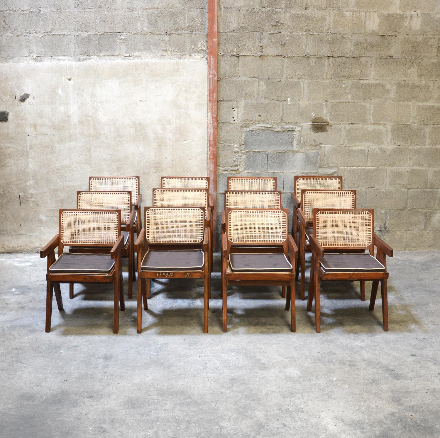 Pierre Jeanneret, set of 12 cane and teak wood office armchairs designed for an administrative building in Chandigarh, India. Back attached to the seat. Teak, woven cane and upholstered new seat cushion featuring cloth covering.

3 Chairs have