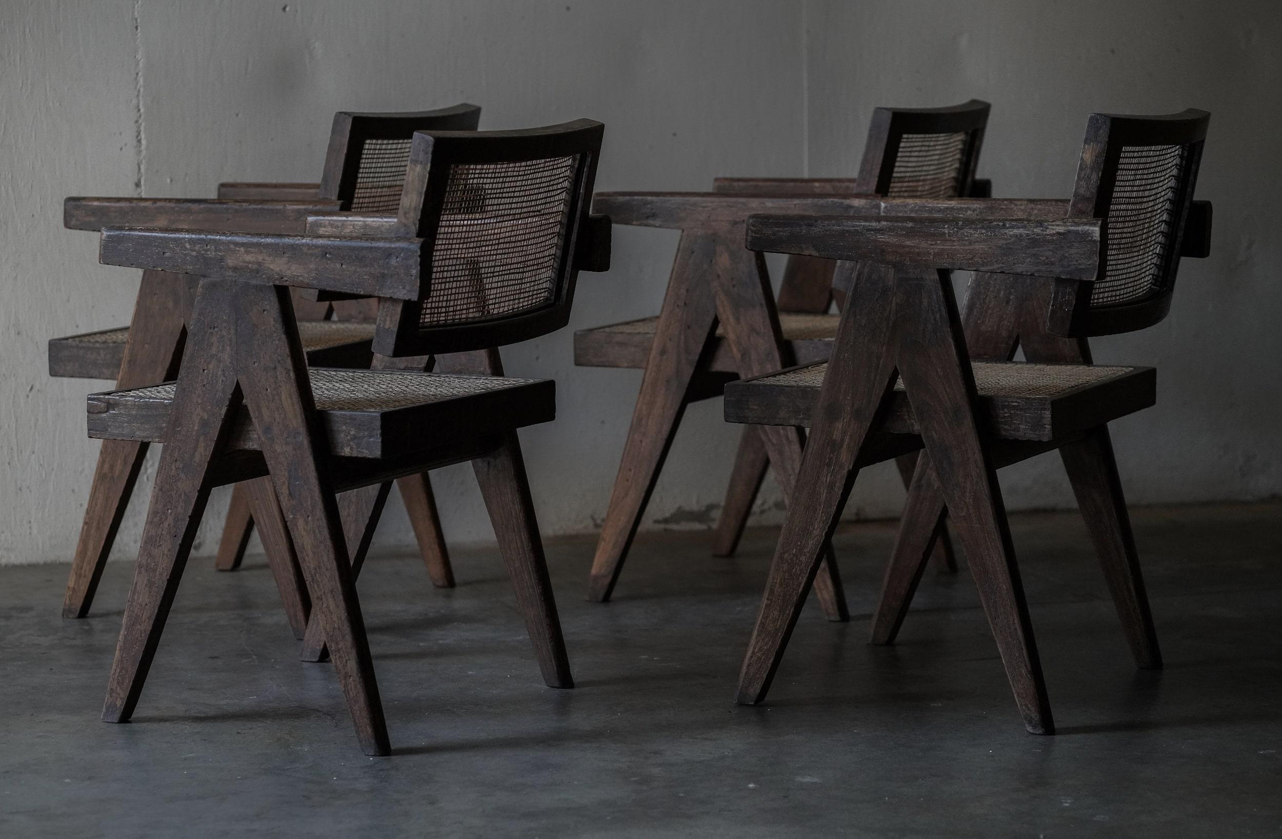 Exceptional set of 6 Pierre Jeanneret caned dining chairs with arms in teakwood with amazing patina and unique lettering. 

All chairs in very good vintage conditions.

Caned in India prior to arrival to me by experts who has been working on these