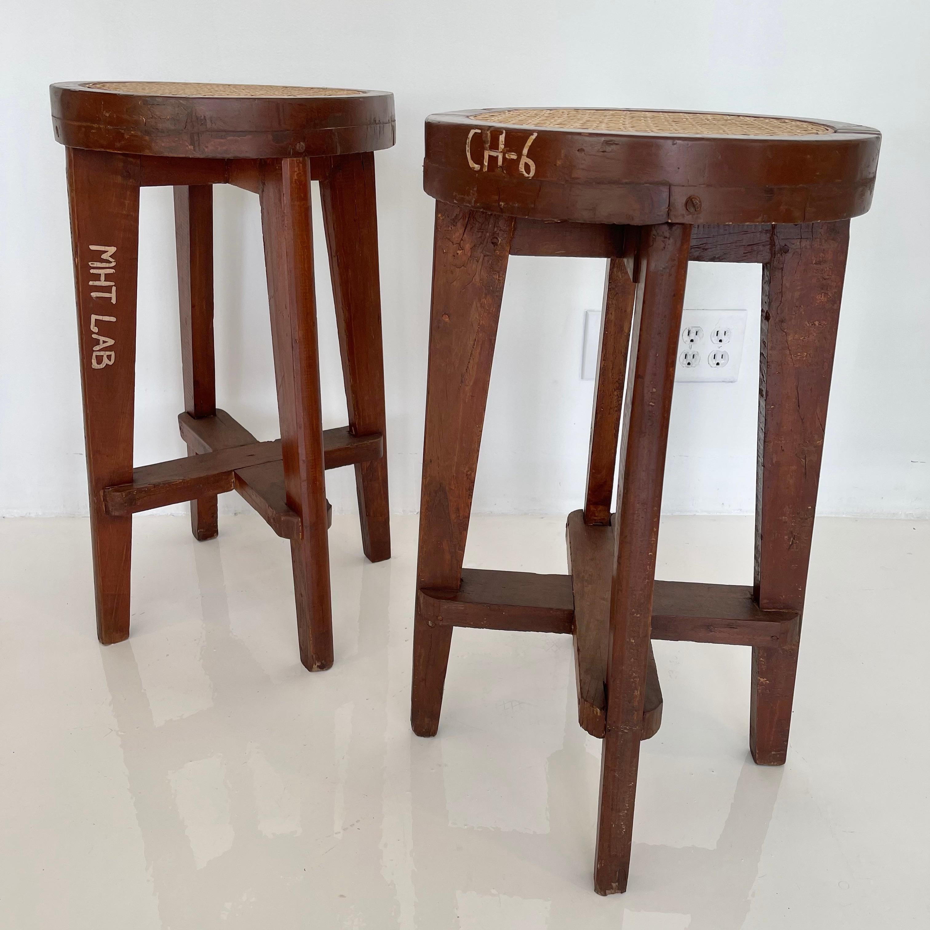 Stunning set of teak stools by Pierre Jeanneret. Model No. PJ-SI-21-A from Panjab University in Chandigarh. Teak stool with cane seat. Great condition. Various numbers and writings on each stool. 6 available. Priced individually.