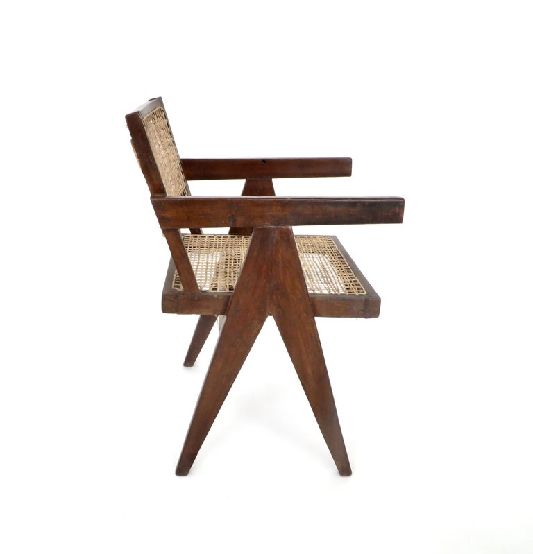 A single armchair called office cane chair by Pierre Jeanneret (1896-1967) from Chandigarh. In teak with cushion and with slightly curved back.
Cane seat and back, circa 1956. New caning as most every chair of this style has been newly caned.