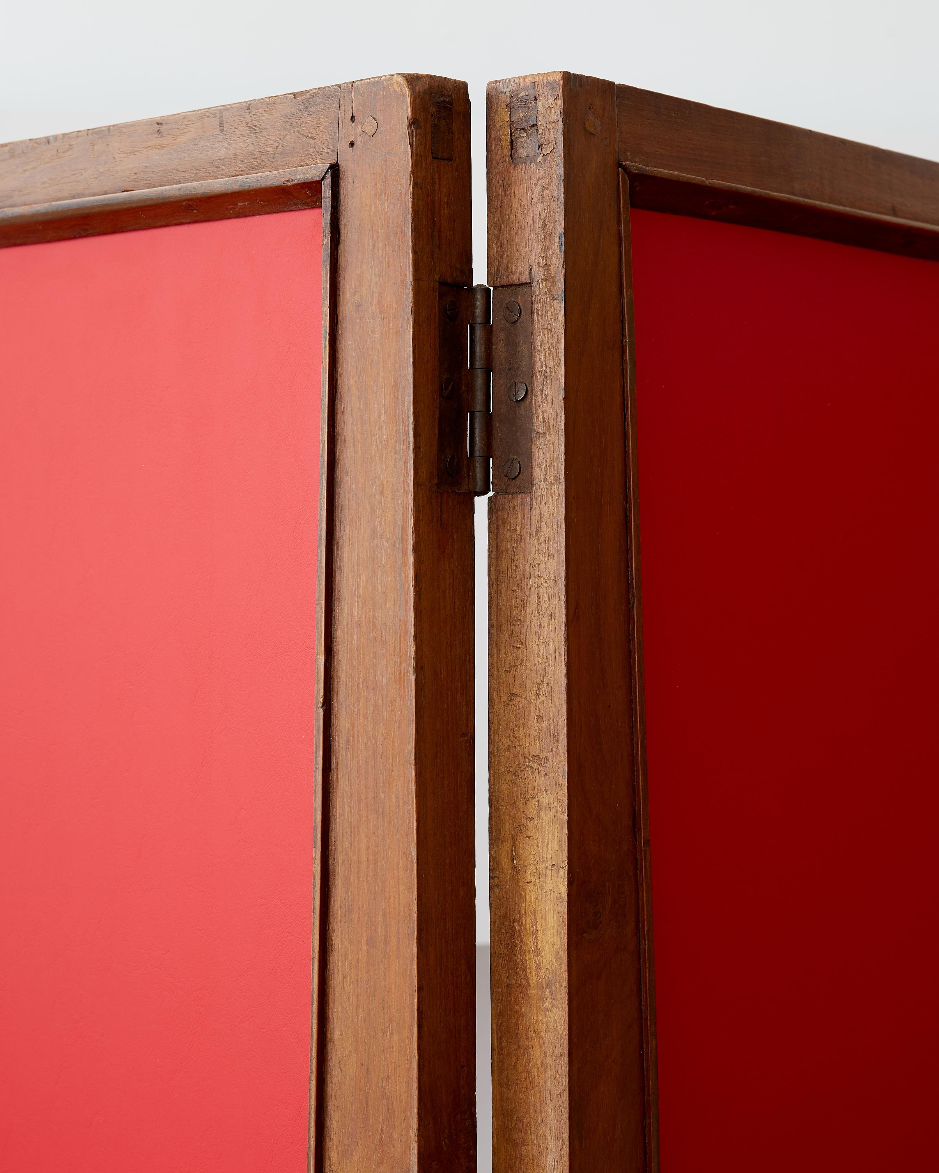 Pierre Jeanneret three-panel folding screen.

Designed for Chandigarh Administrative Buildings c. 1957.

Teak, red leather.

Three double-sided panels, each with a profiled frame.

All hardware, including brass hinges, are original.

Measurements: