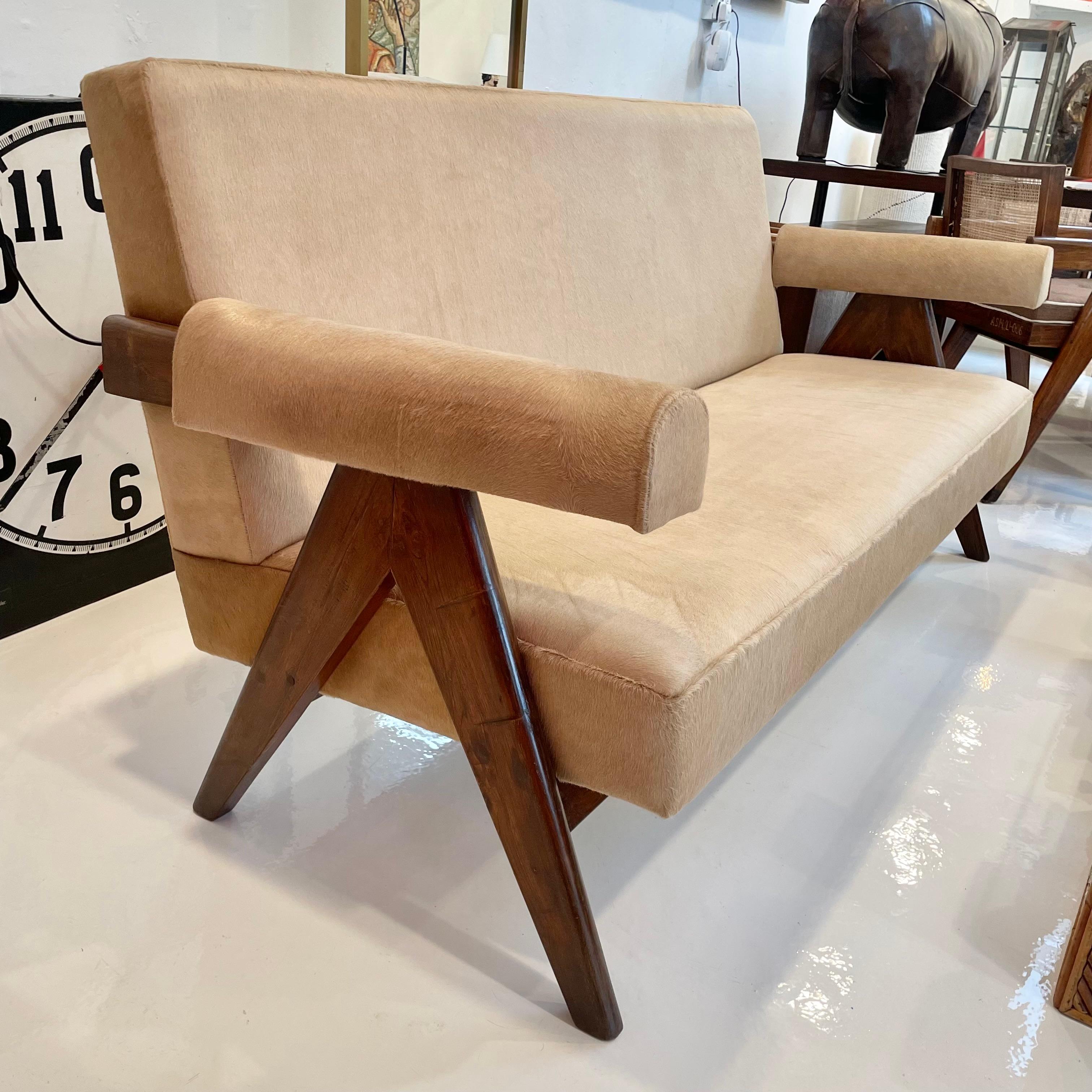 Stunning teak sofa fully reupholstered in beige cowhide designed by Pierre Jeanneret for Chandigargh. Rectangular seat resting on two compass type side legs. New cushions. Sofas were used in the hostels and hotels for civil servants. Purchased