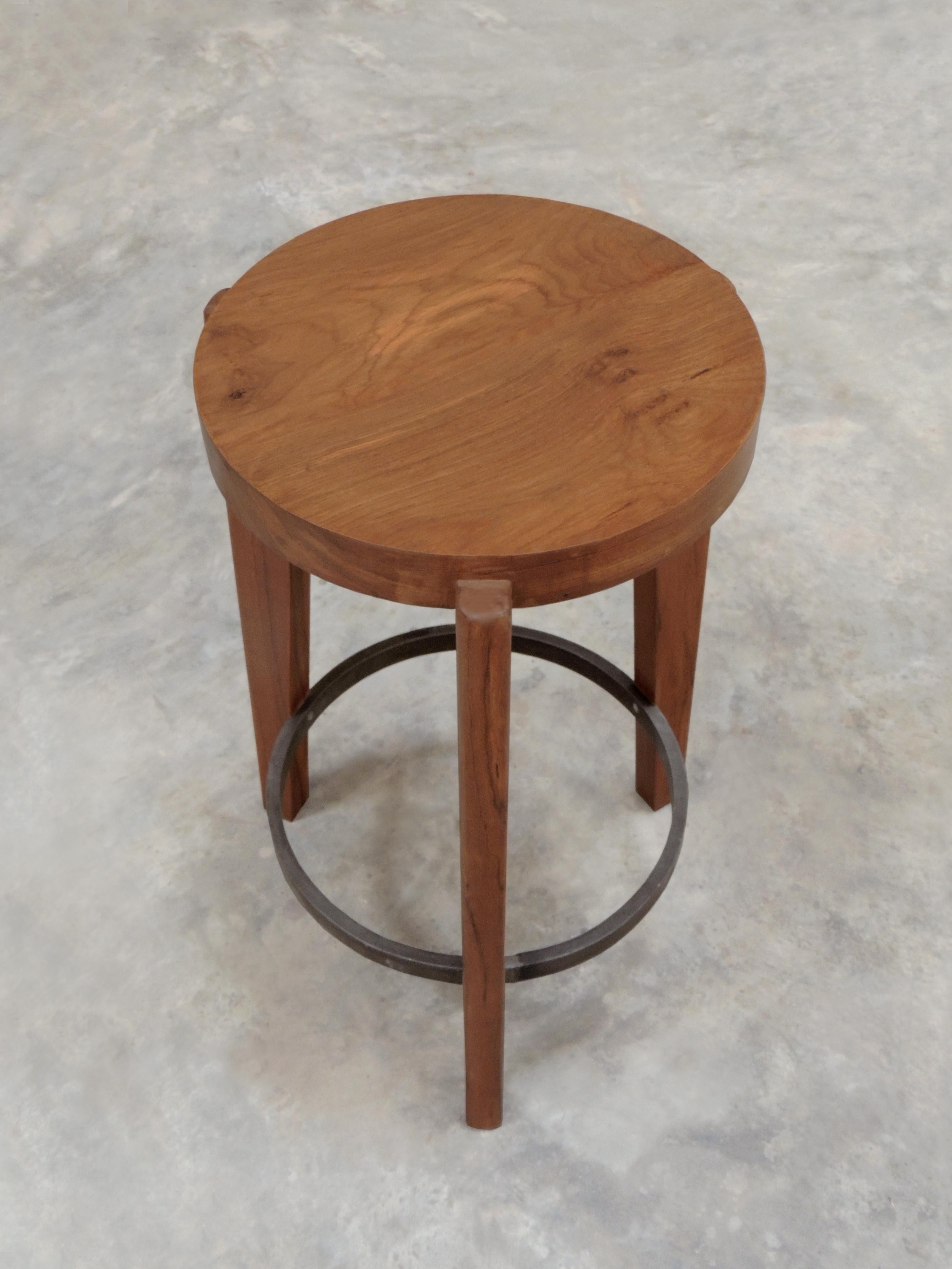 Pierre Jeanneret's side table/stool - hand-sculpted contemporary reedition

The counter stool or round stool has a solid teak seat with two metal rings - one at the foot of the stool and a smaller ring supporting the seat. The seat is gently