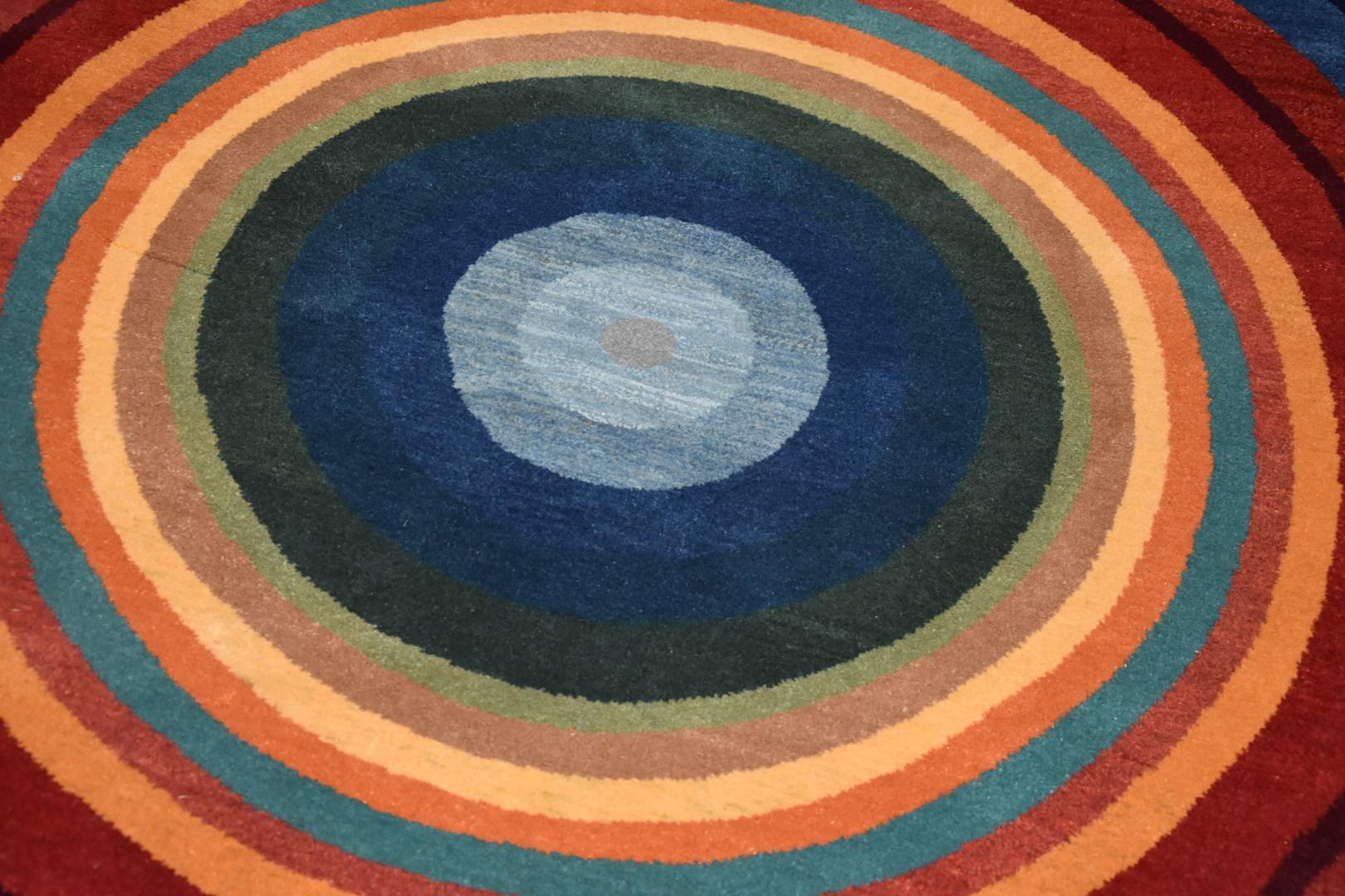 Beautiful round Persian rug with multiple colors such as blues, yellows, oranges, greens... It is very original and hand-crafted by the franco-iranien artist Pierre Kiandjan. With its circular shapes, it reminds us of the famous Delaunay's couple's