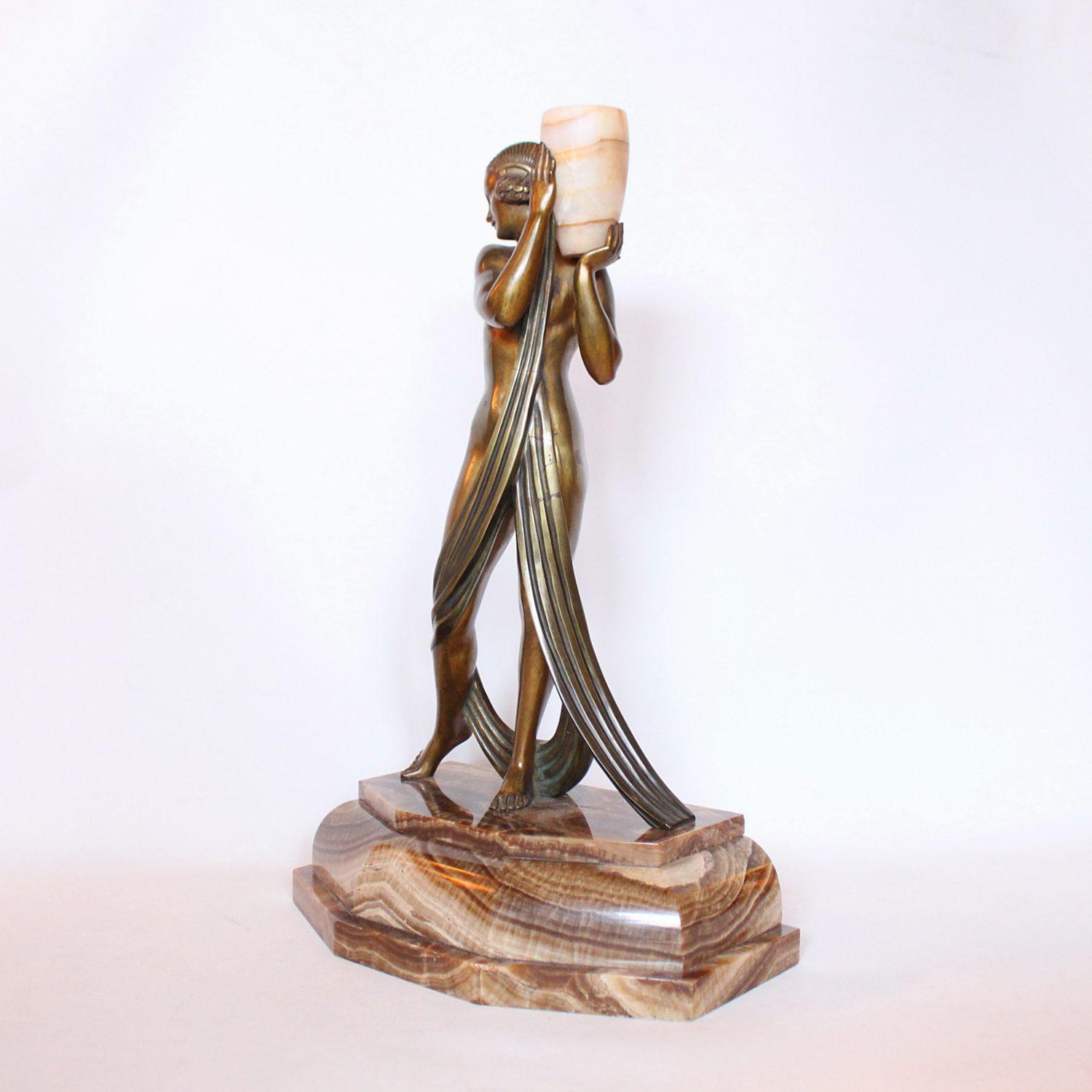 ‘Water Carrier’, an Art Deco gilt bronze sculpture of a young lady holding aloft a marble urn. Set over a shaped marble plinth. Signed P Laurel to marble


    