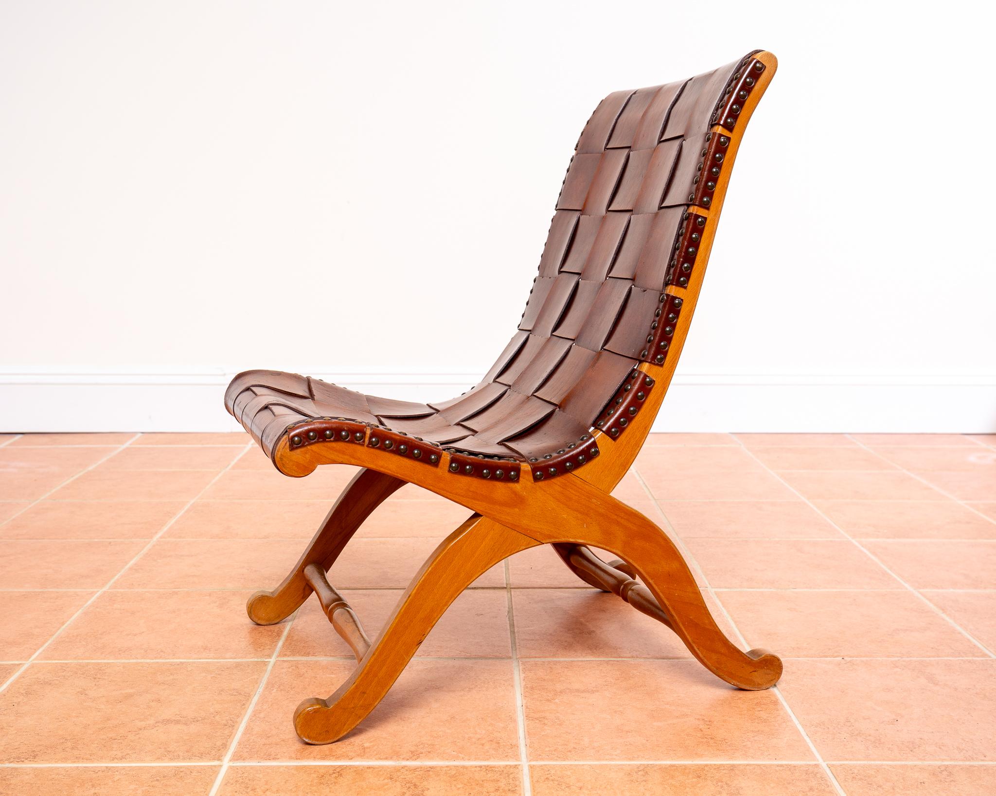 A stunning and rare beech wood and cigar leather strap slipper chair in lovely condition. Attributed to Pierre Lottier for Valenti in the early 1960’s, this gorgeous low lounge chair will add a handsome and sophisticated Neoclassical look to any