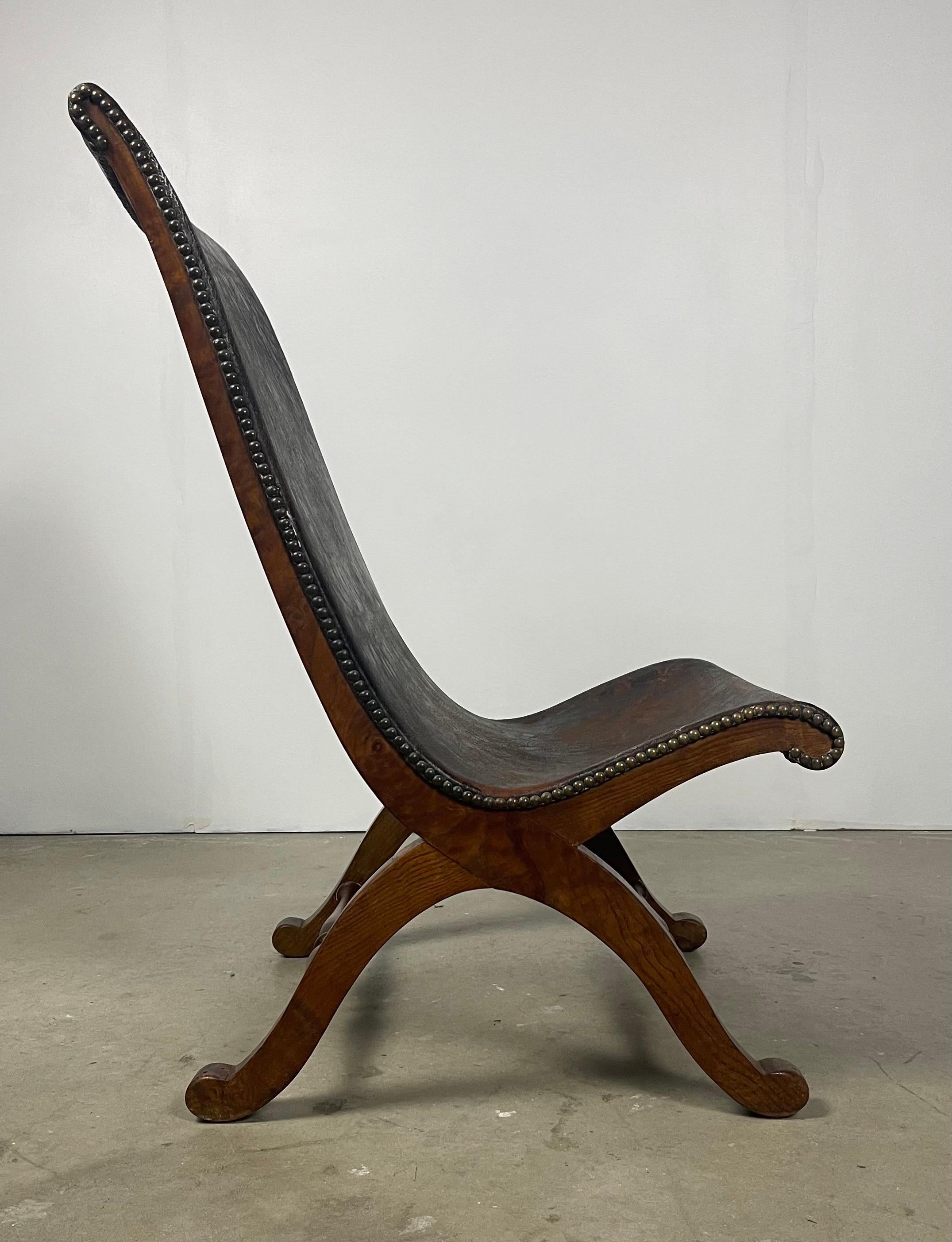 Mid-century leather and oak fireside sling chair by Pierre Lottier. Original condition with no restoration or replacement.