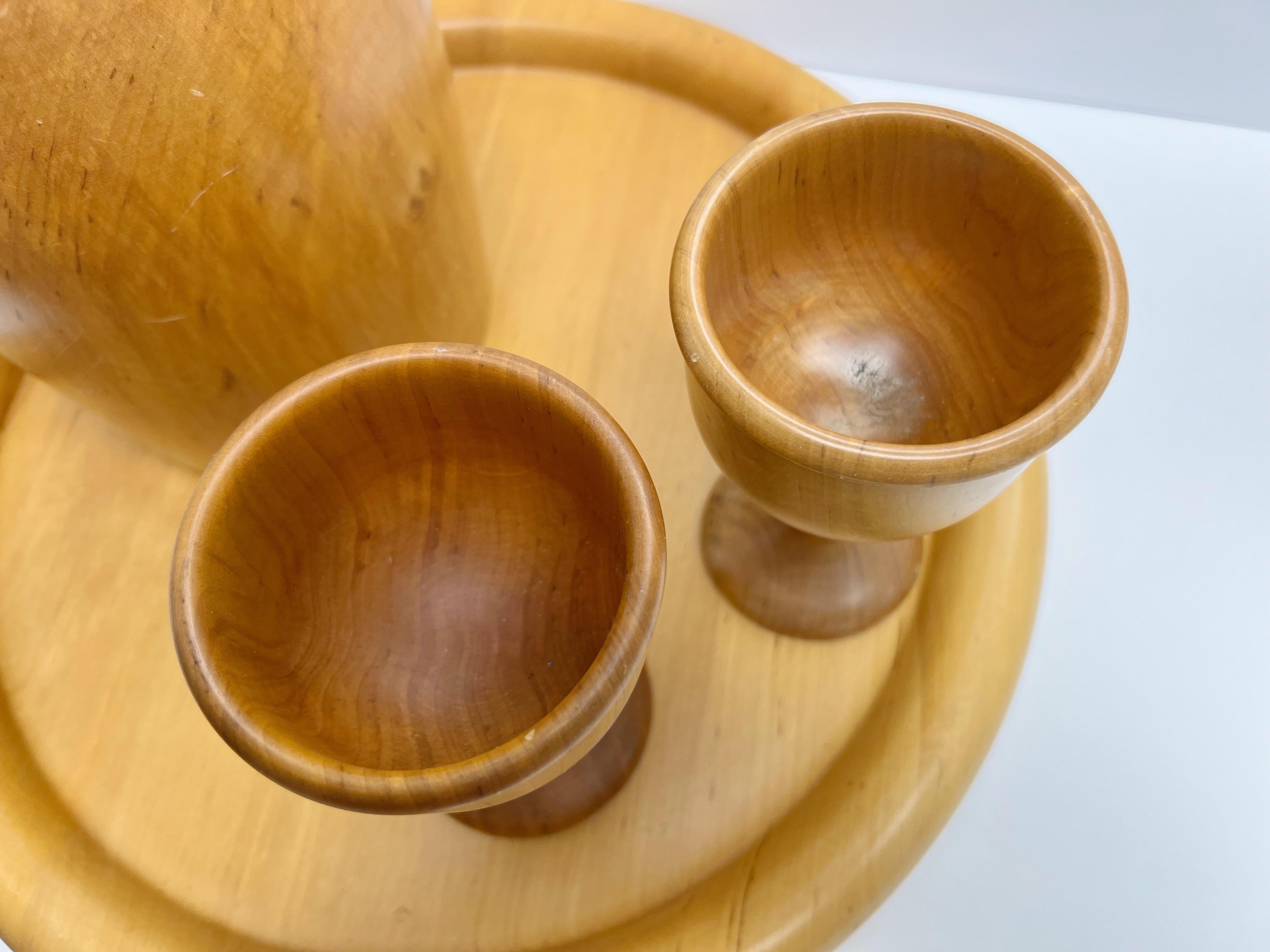 A carved set that includes a tray, a thermos Jug with cork stopper, and 2 cups,