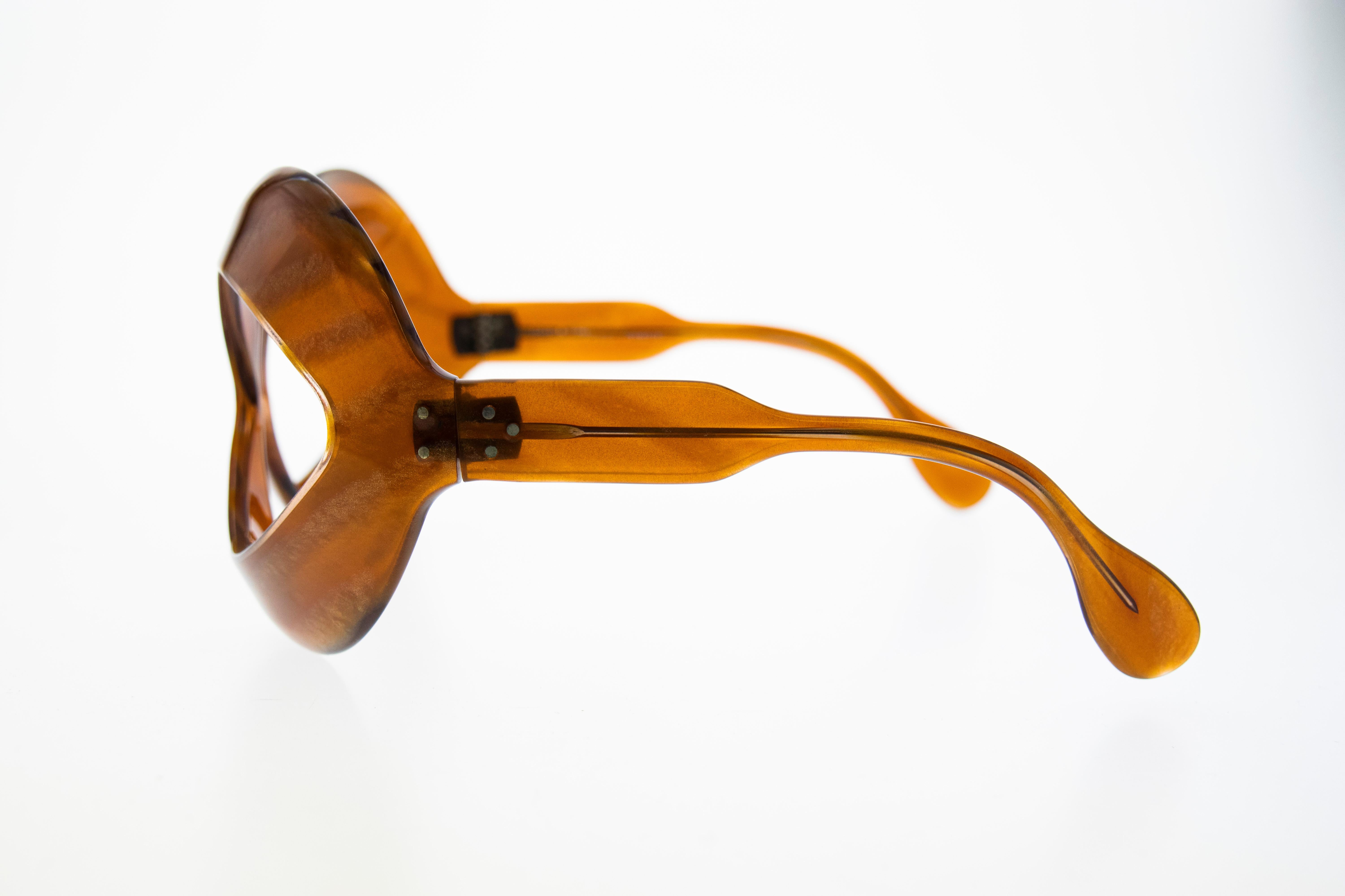 Cette lunette de soleil cocktail à la monture futuriste et surdimensionnée a été conçue par Pierre Marli et fabriquée en France. La couleur brune, une autre est plusieurs couleurs dans un seul cadre. 