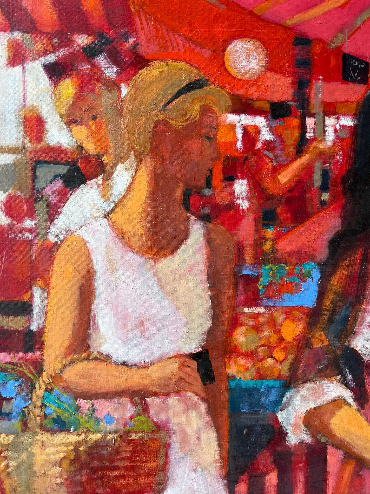 Femmes déambulant dans les étals d'un marché rouge vif rempli de produits et d'huile française en vente 1