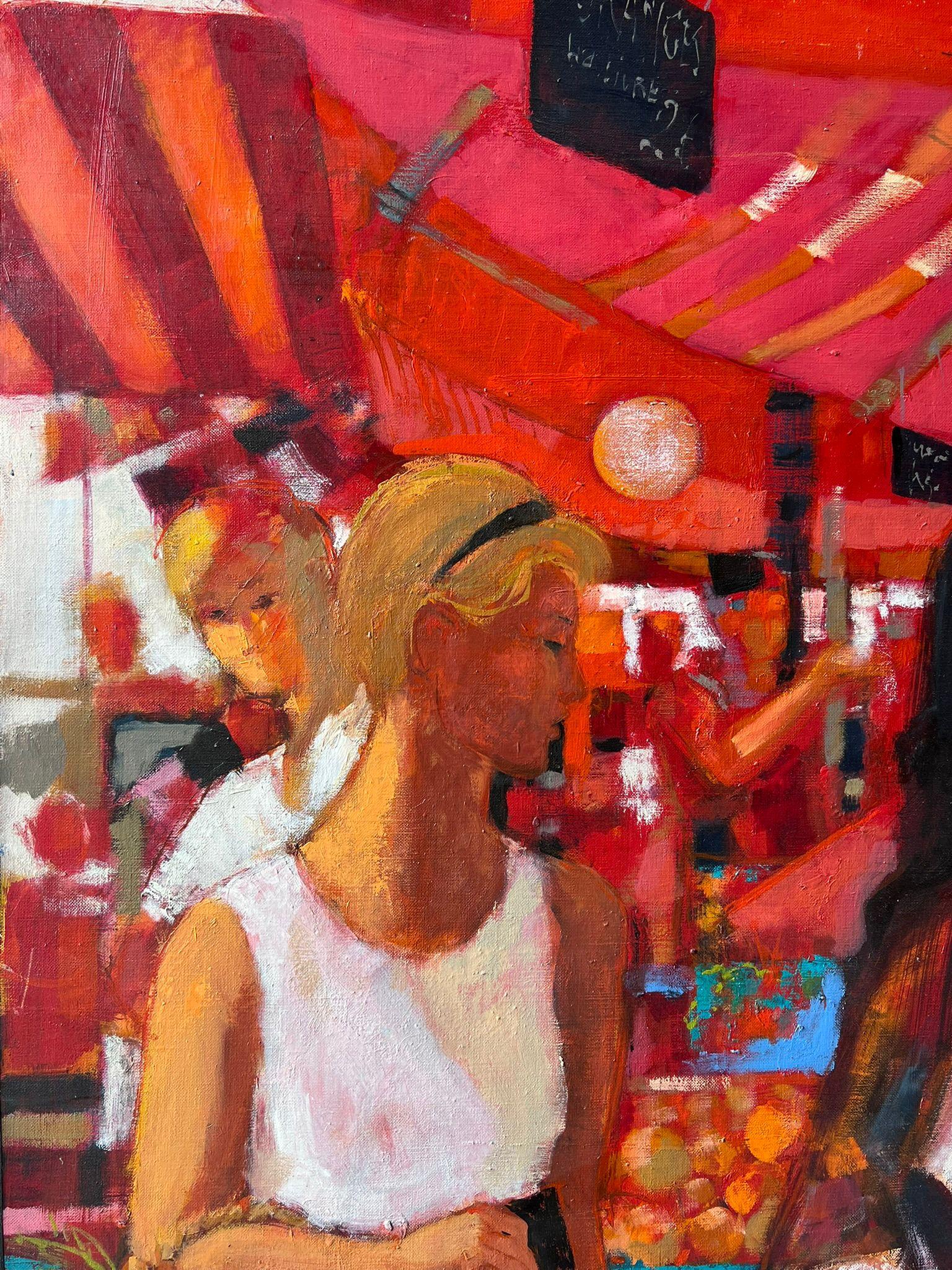 Femmes déambulant dans les étals d'un marché rouge vif rempli de produits et d'huile française en vente 2