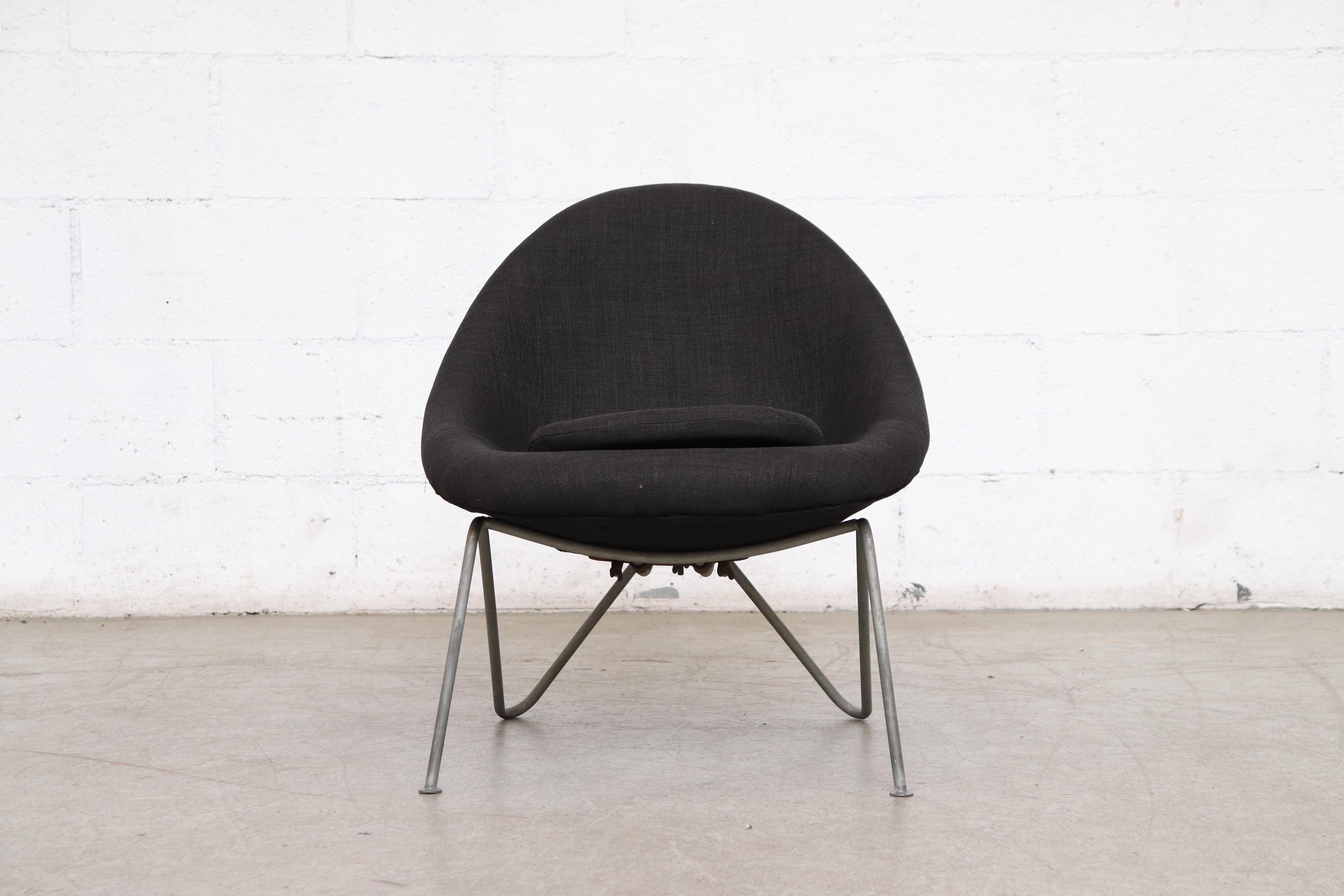 Single petite midcentury bucket chair newly upholstered in black fabric with original grey bent wire enameled metal frame with visible wear consistent with age and use.