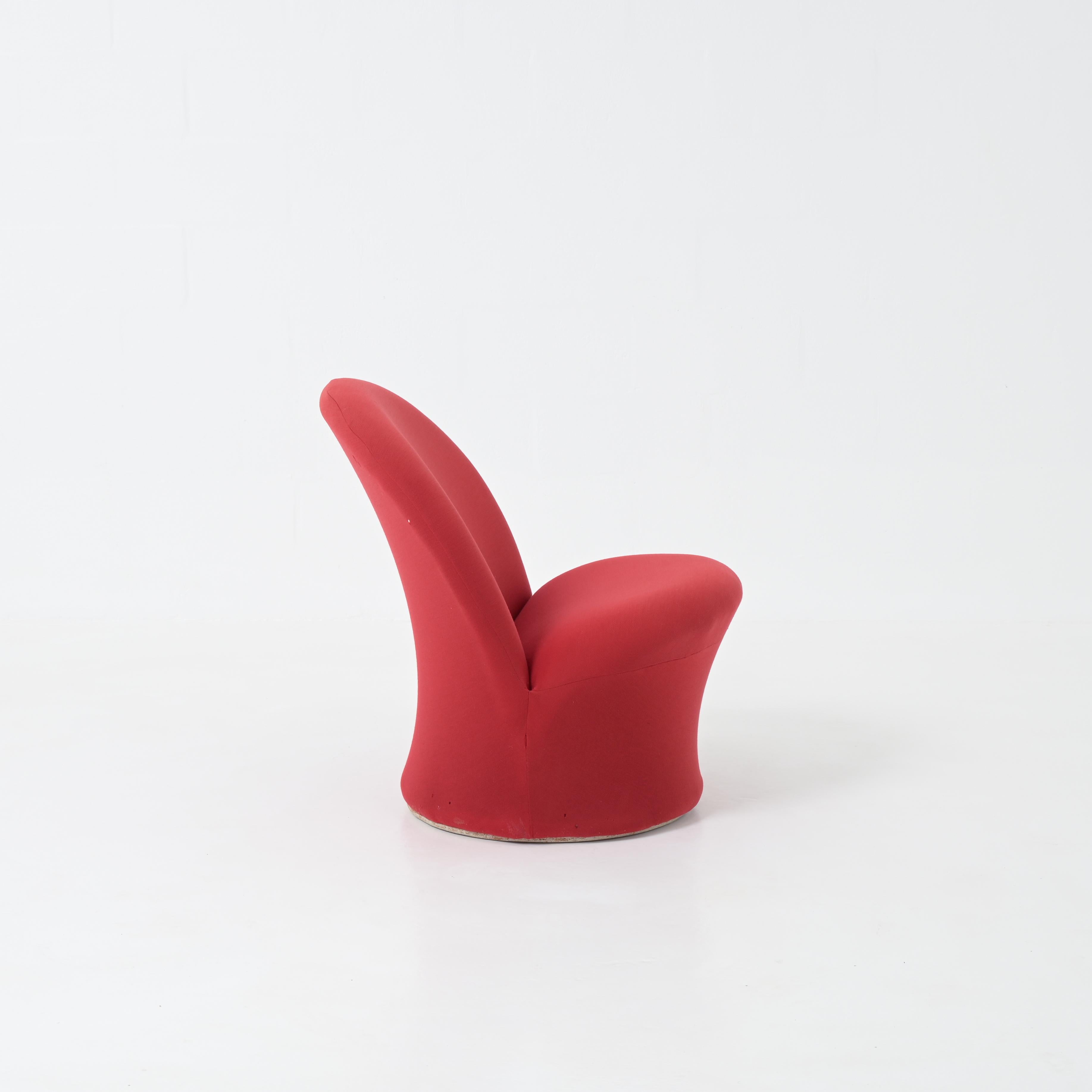 En 1967, Pierre Paulin a conçu pour Artifort cette chaise confortable, ronde et sculptée. Le modèle F572 n'a été produit que pendant quelques années et est aujourd'hui une pièce rare. Sa structure est en acier et il est tapissé d'un tissu rouge