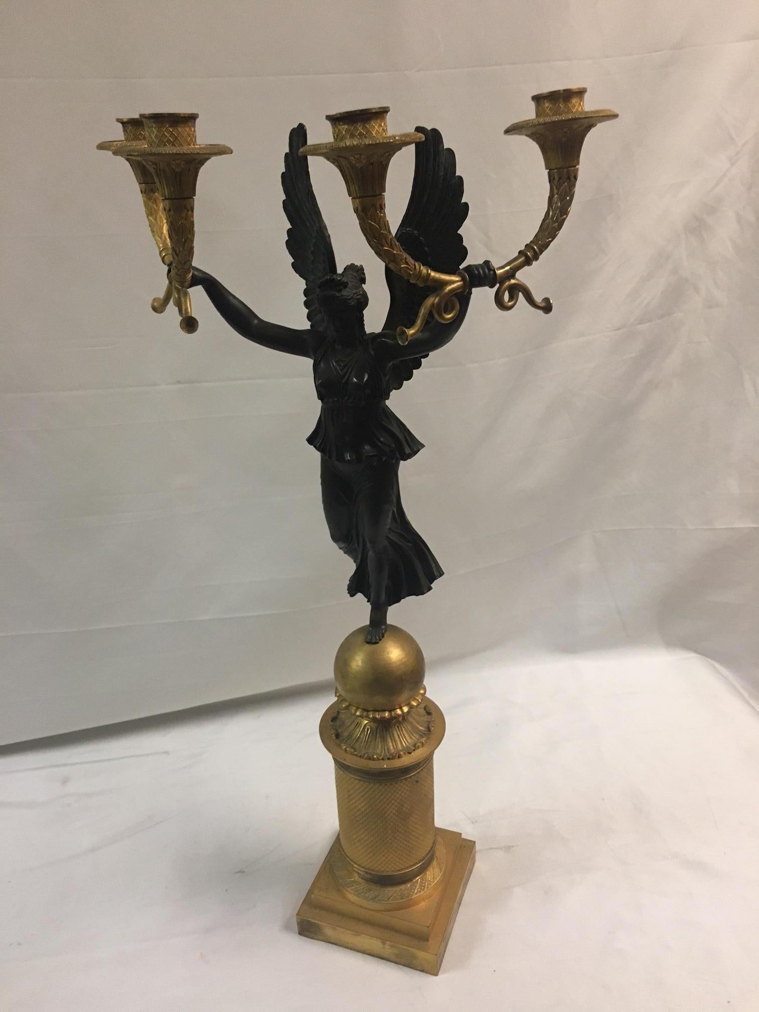 Un raffinato candelabro a quattro luci in bronzo dorato in stile Impero francese con l'allegoria 