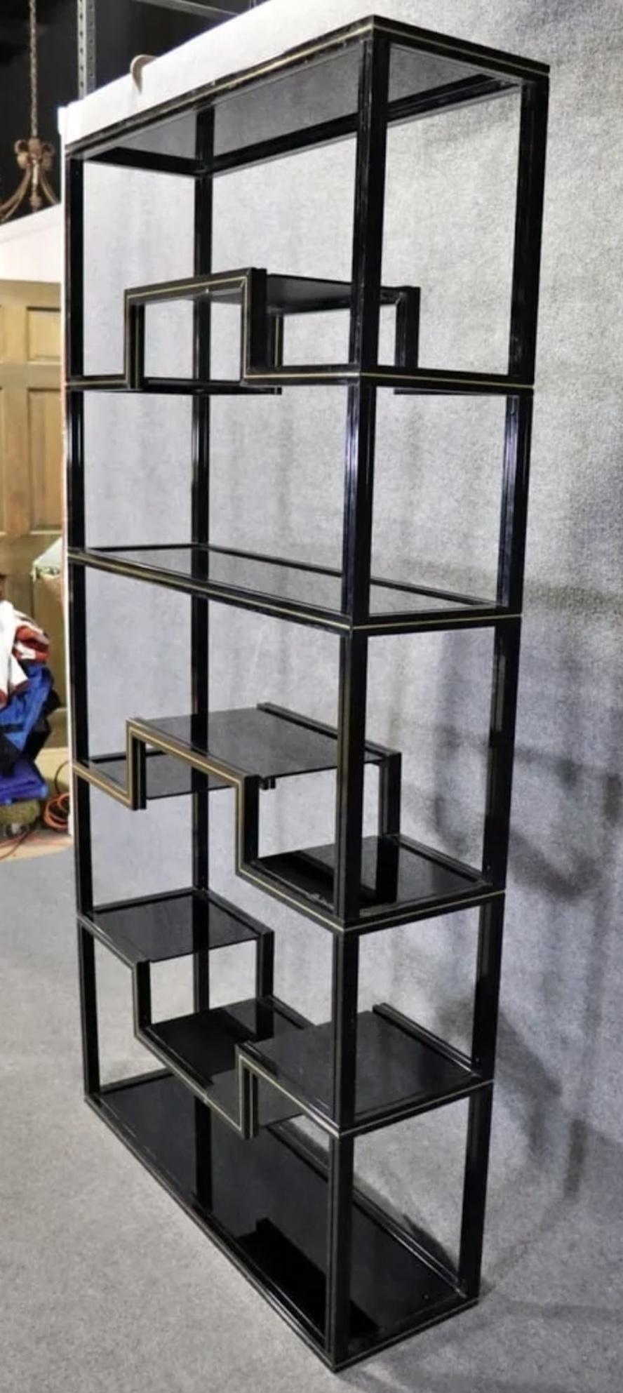 Tall standing bookcase by Pierre Vandel features black lacquered metal with brass trimming. Smoked glass shelves, geometric design frame, standing over six feet tall.
Please confirm location NY or NJ
