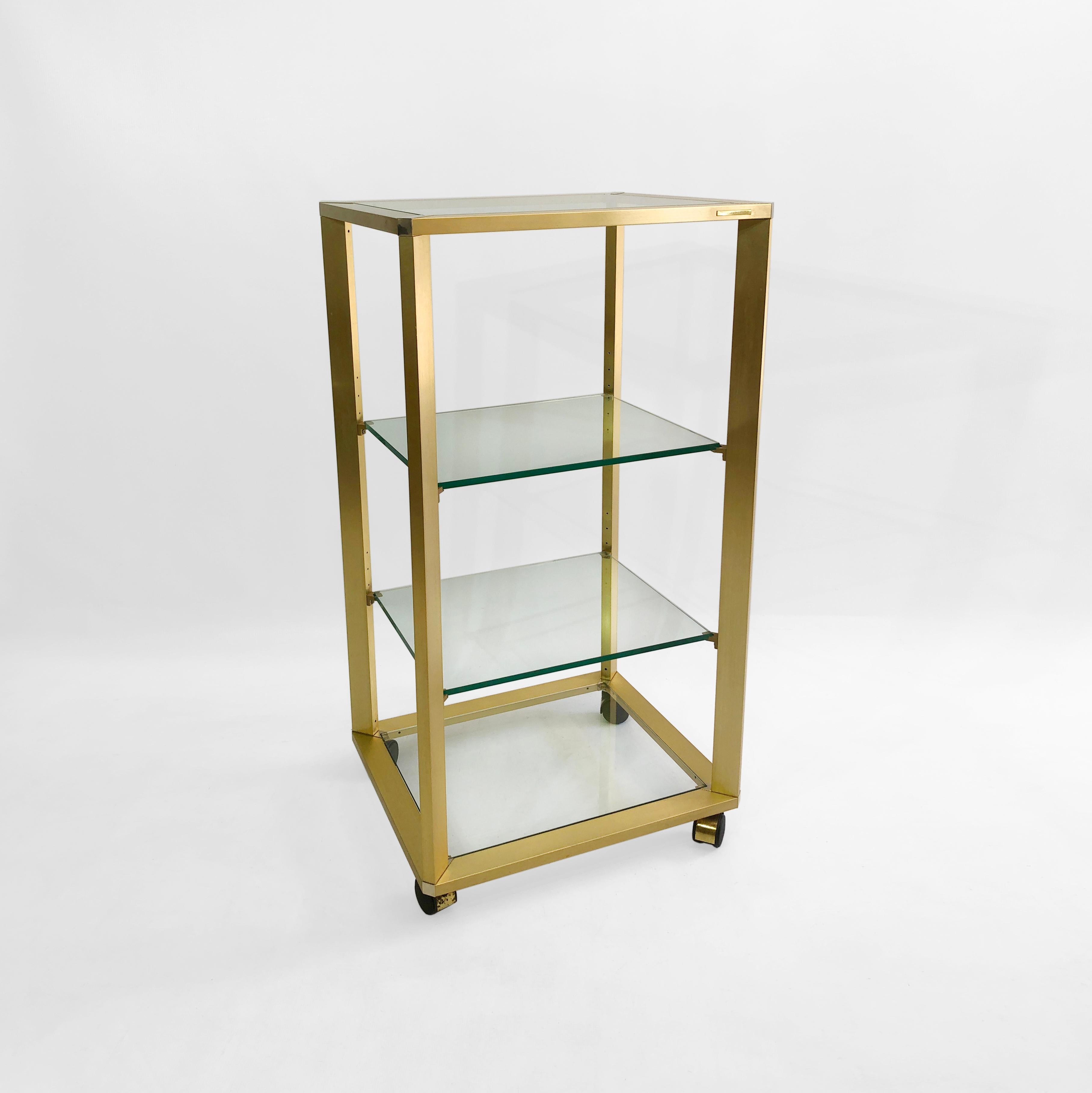 This gold, waist high étagère, is a rarely seen piece of Pierre Vandel design - but has all the hallmarks of his best work. The four-shelved unit is mounted on to four metal swivel castor wheels, allowing for free movement. The frame is gold-plated