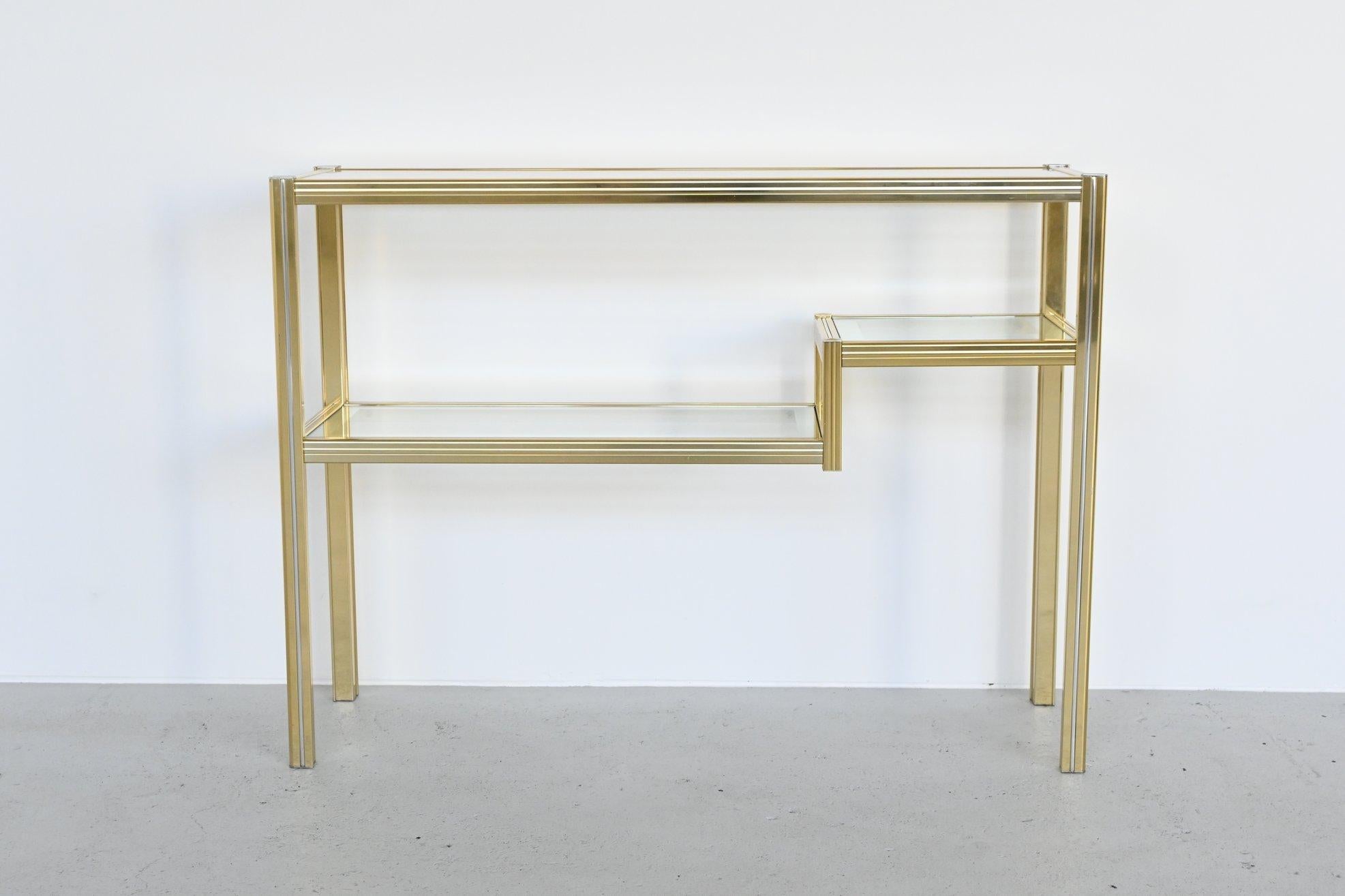 Beautiful high console table designed by Pierre Vandel, France 1970. This double level table has a brass metal frame with a chromed aluminium rim that support 3 glass plates with mirrored edges. It’s very decorative, practical to use and in very