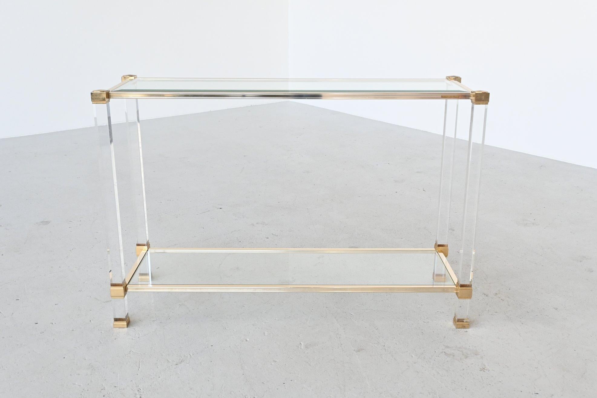 Beautiful high console table designed by Pierre Vandel, France, 1970. This double level table is made of Lucite pillars with brass connections that support 2 glass plates. It’s very decorative and practical to use. The table is marked with a brass