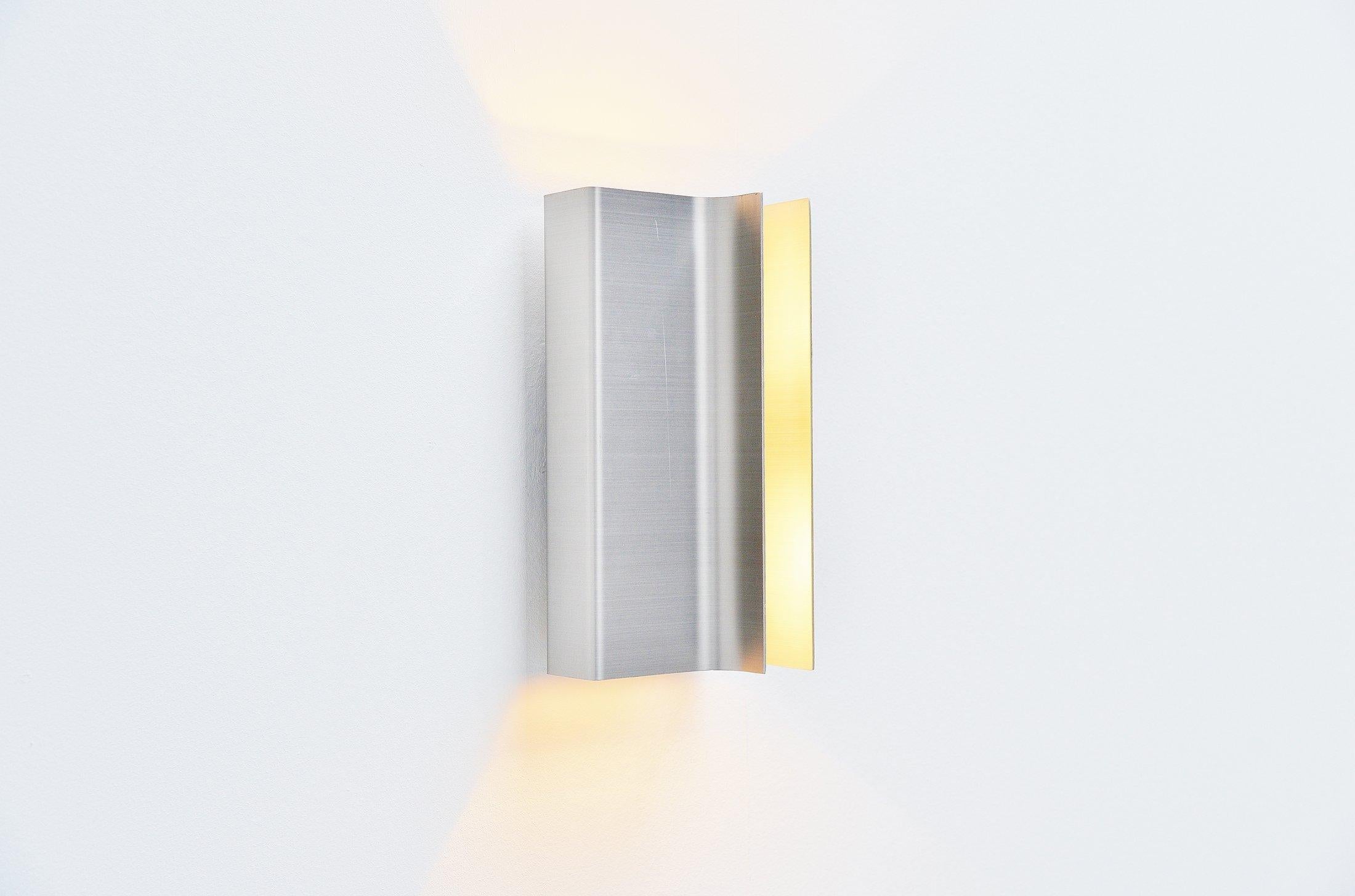 Very nice aluminium sconces model C-1609 designed by Pierre Vandel and manufactured by RAAK Amsterdam, Holland, 1972. These so called Architraaf sconces are made of solid folded aluminium and have a very nice shape. They give because of the unusual