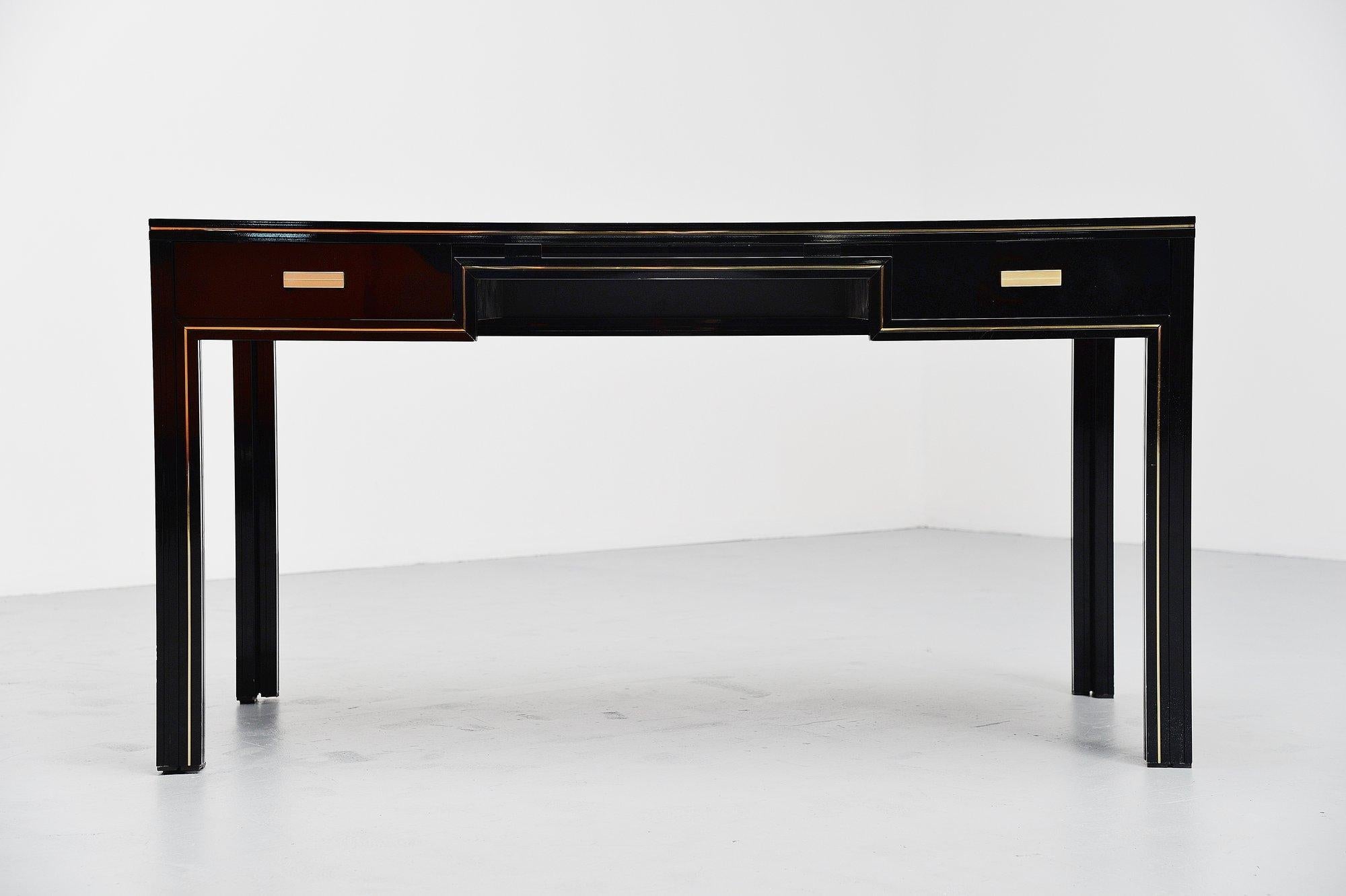 Nice classic black writing desk designed and manufactured by Pierre Vandel, France, 1970. This black painted metal desk with brass details has a very nice minimal look but still looks very classy. This desk has 2 drawers and a black glass top. Very