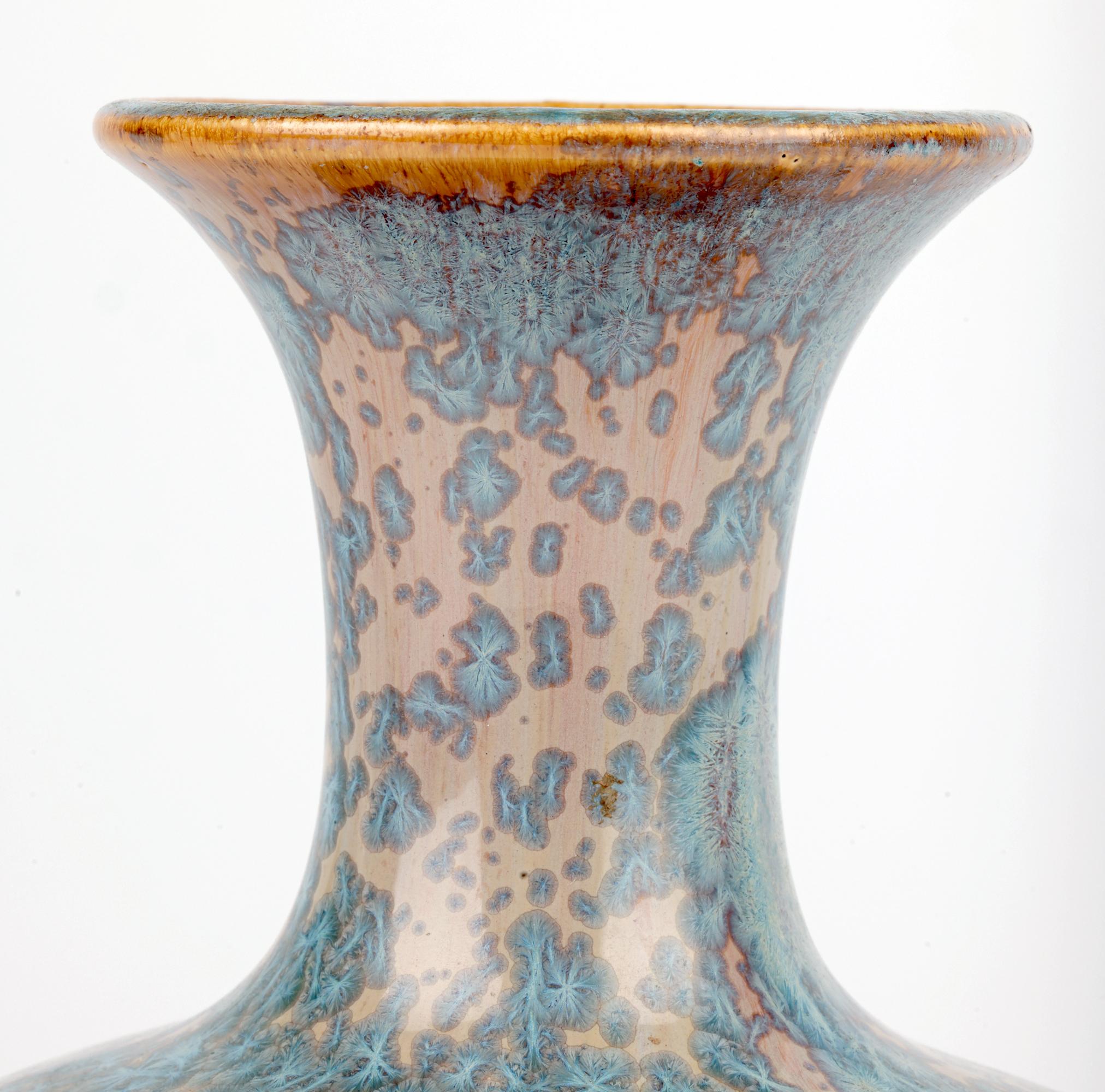 Uno splendido ed elegante vaso francese Art Decor a forma di bottiglia decorato con smalti cristallini blu e risalente al 1920 circa. Il vaso in gres a forma di bottiglia poggia su uno stretto piede rotondo non smaltato con una base leggermente