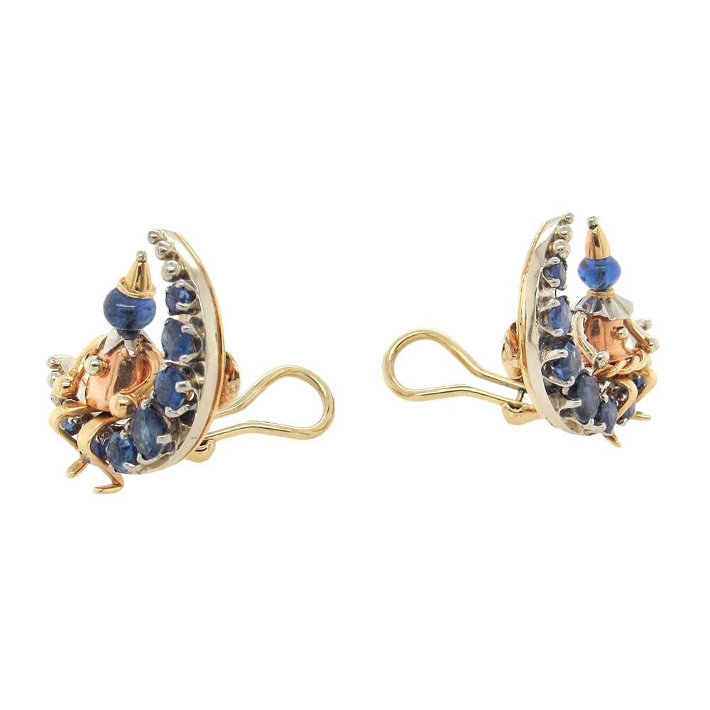 Remarkable design and craftsmanship, 18K ‘Man on the Moon’ earrings, circa 1950, sit a rose gold “Pierrot” figure on a sapphire-set crescent moon, the Pierrot with a sapphire bead head and the clip-on earrings, 3/4″ x 7/8″, fashioned in detail in