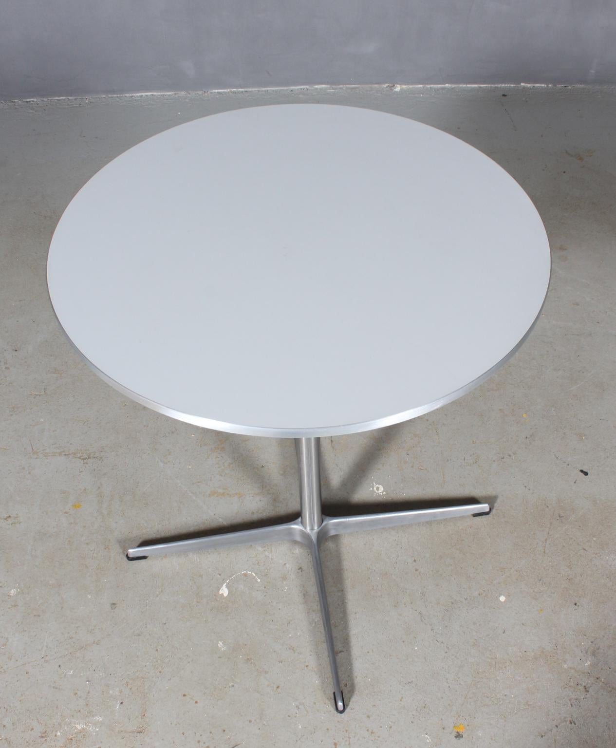 Piet Hein & Arne Jacobsen café / kitchen table with plate of grey laminat and aluminium side.

Four star base of aluminium and steel.

Made by Fritz Hansen.