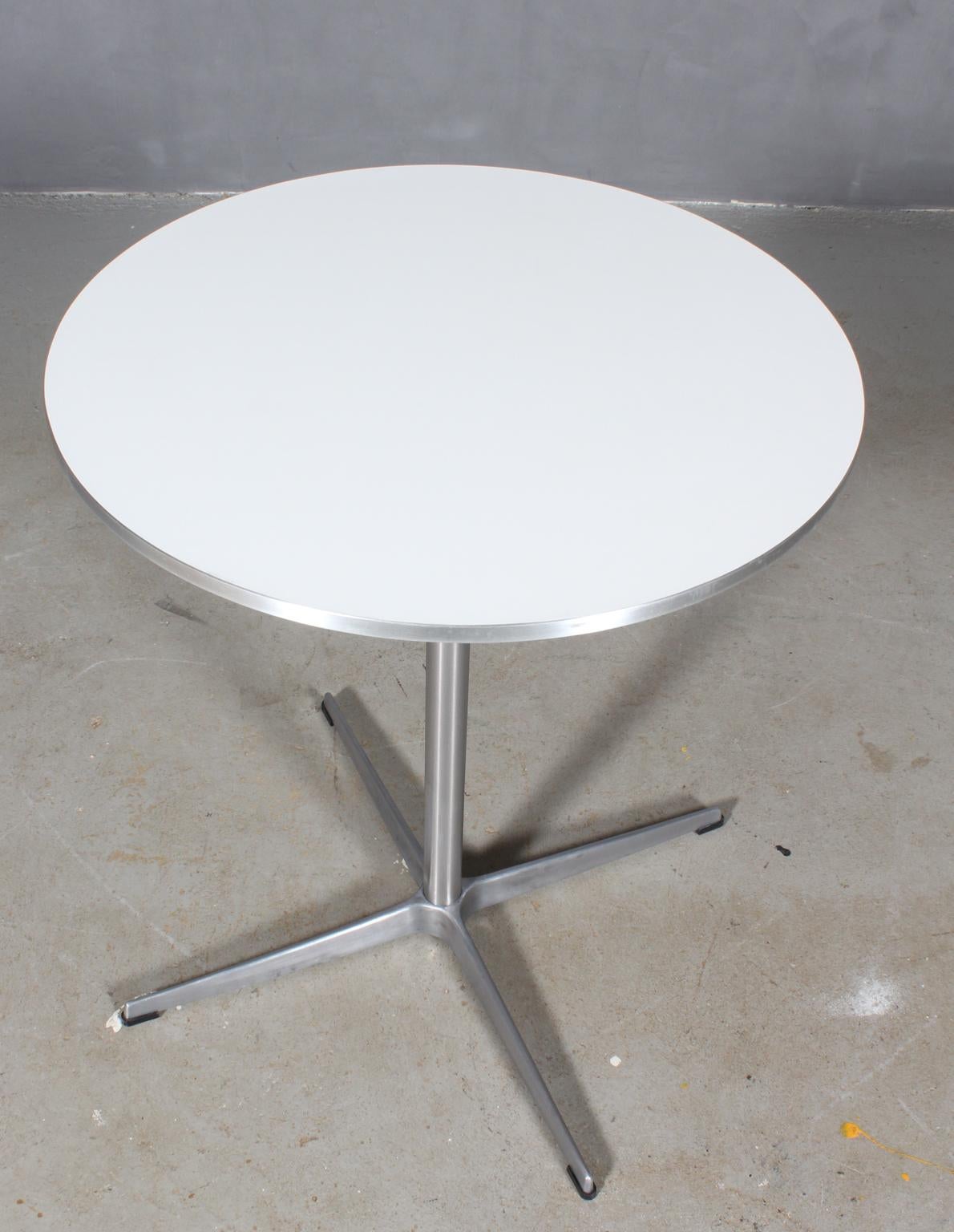 Piet Hein & Arne Jacobsen café / kitchen table with plate of white laminat and aluminium side.

Four star base of aluminium and steel.

Made by Fritz Hansen.