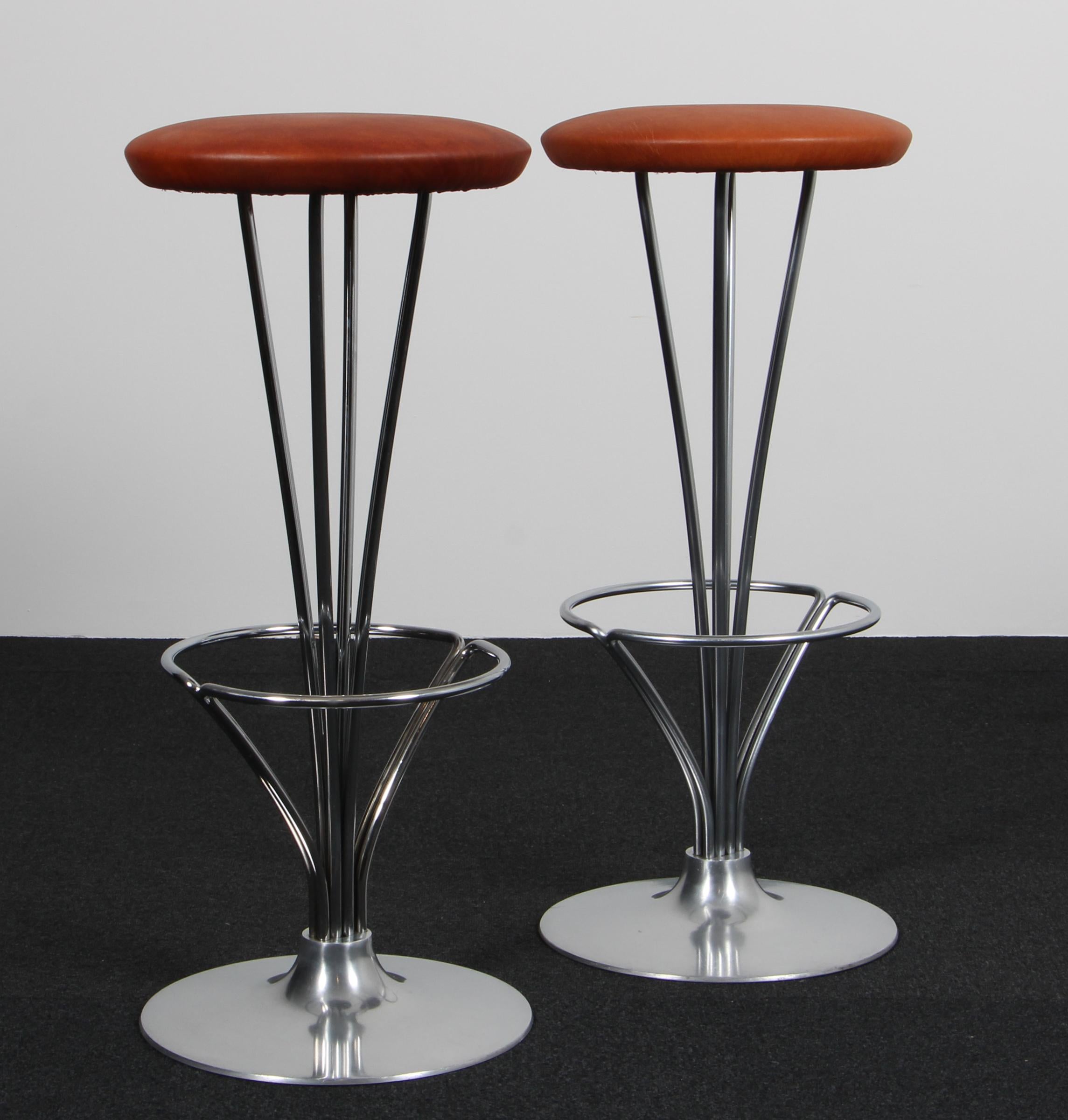 Piet Hein bar stools new upholstered with black pure full grain aniline leather.

Made by Fritz Hansen.