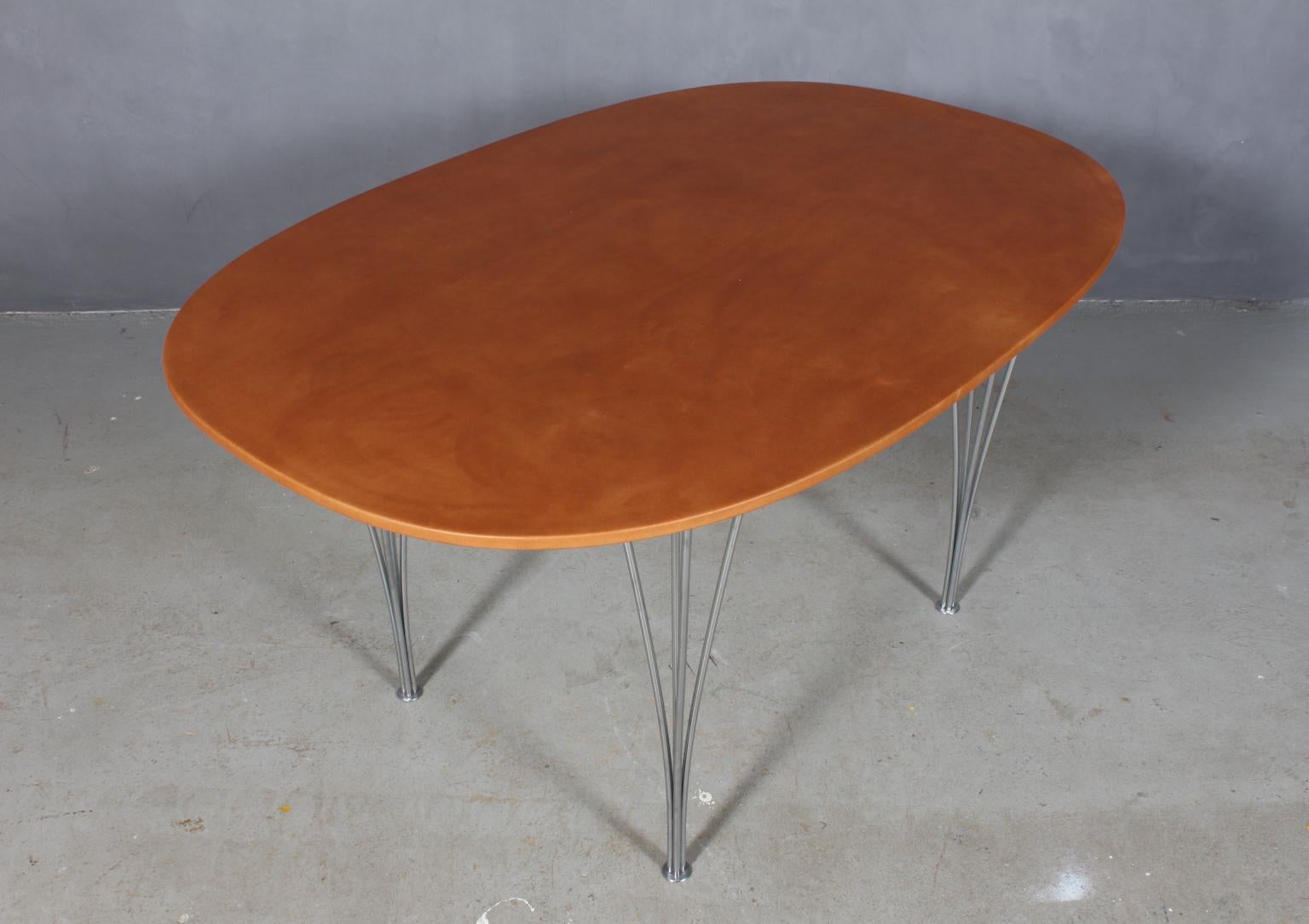 Piet Hein & Bruno Mathsson super ellipse dining table with new upholstered plate with cognac vintage aniline leather.

Spring legs of chrome.

Model 3513, made by Fritz Hansen.

The leather upholstery gives a unique and strong surface which