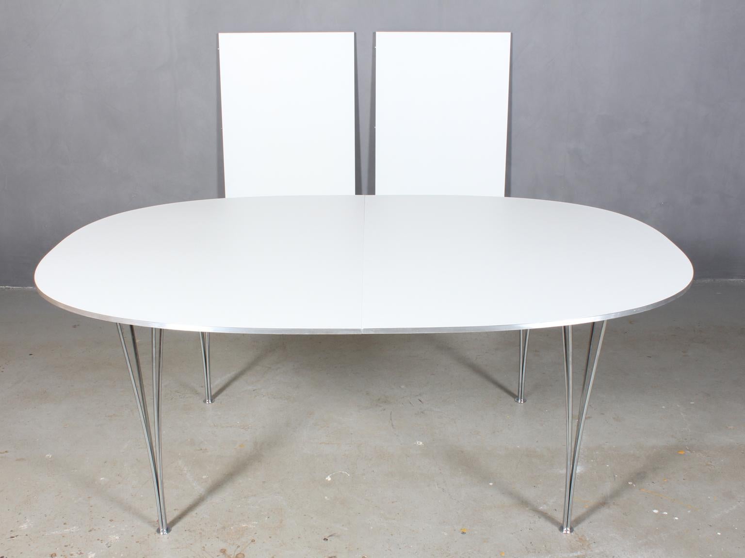 Table de salle à manger Piet Hein & Bruno Mathsson avec nouveau plateau blanc laqué professionnel. Liste latérale Alu.

Deux feuilles d'extension de 60 cms.

Pieds en métal chromé.

Modèle Super Elipse, fabriqué par Fritz Hansen.

C'est