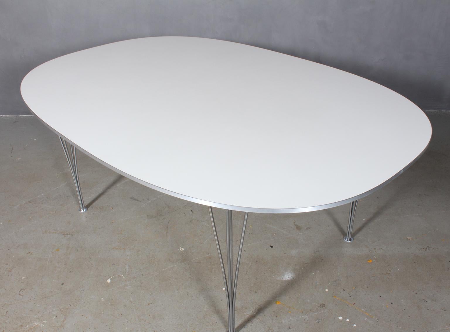 Piet Hein & Bruno Mathsson ellipse dining table white laminate. Alu list on the side.

Legs in chromed steel.

Made by Fritz Hansen.
  