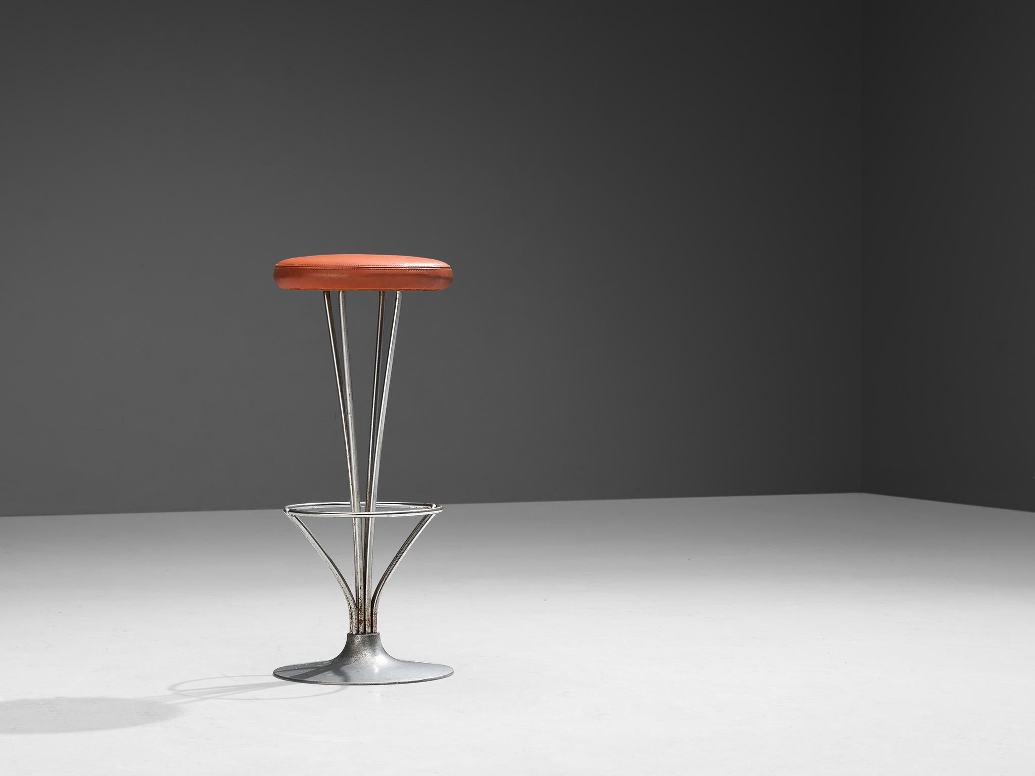 Piet Hein for Fritz Hansen, barstool, metal, red leatherette upholstery, Denmark, 1970s
 
From a round base the stem parts into three slim rods that hold the round seat upholstered in red leatherette. A ring is fixated to the stem and functions as