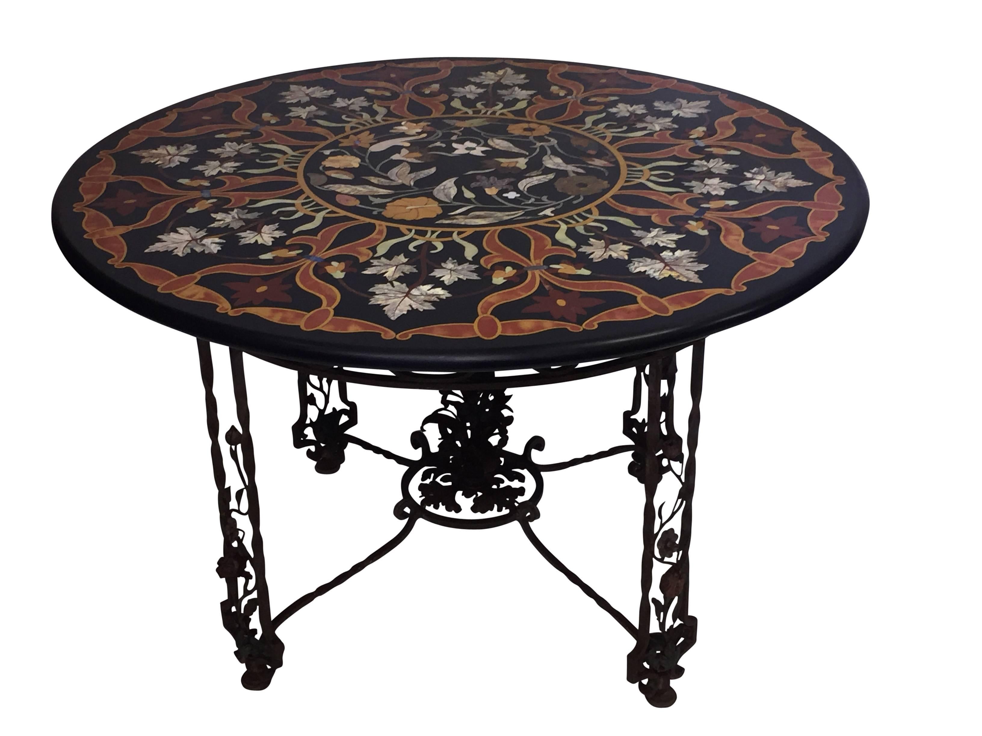 An Italian garden or center table, having a wrought iron base with vining leaves and flowers and a large Pietra Dura (inlaid stone) tabletop. Exceptionally fine stone specimen top with beautiful design and colors, Italy, 1930s.