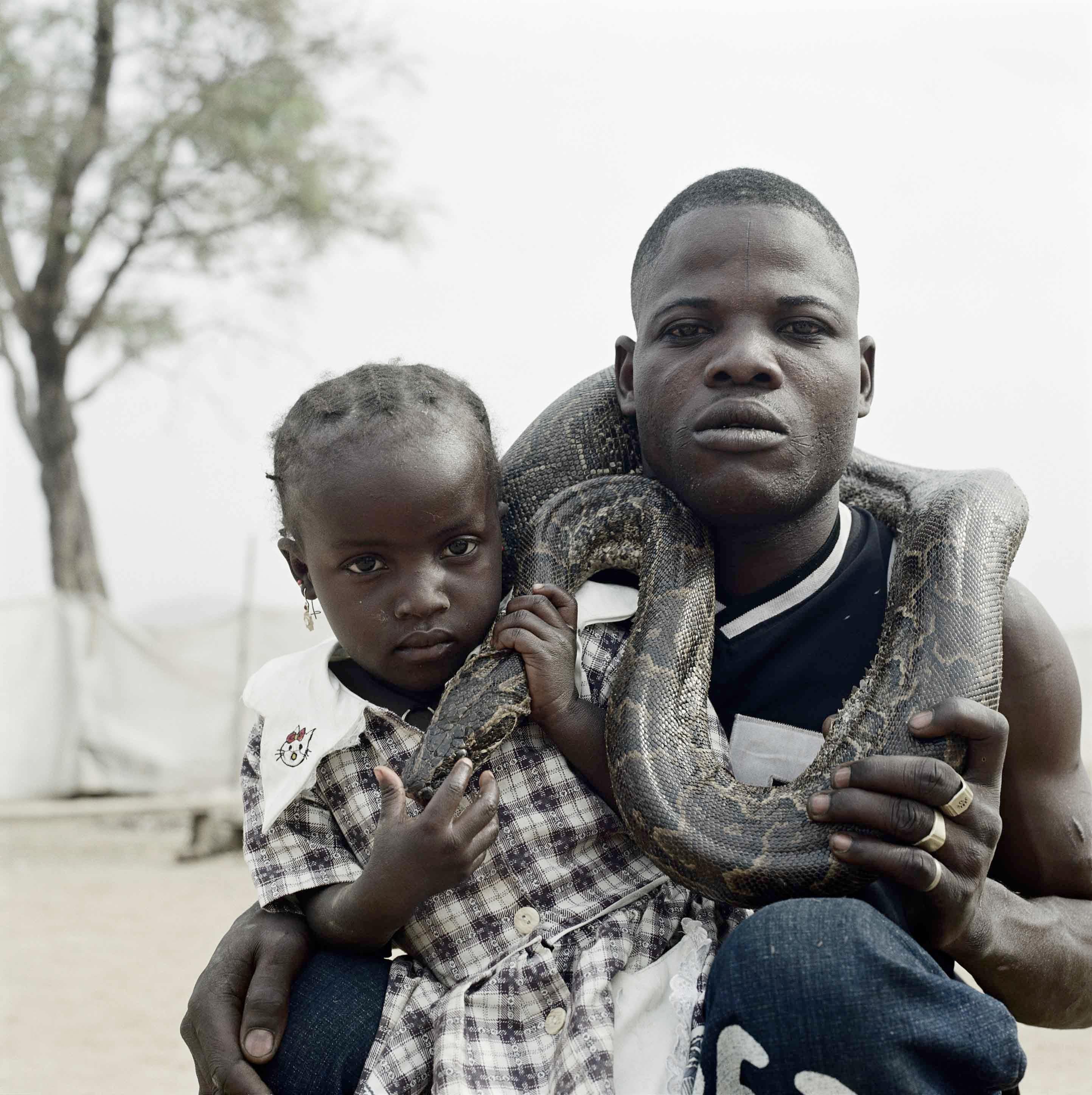 Mummy Ahmadu and a Snake Charmer with a Rock Python, Abuja, Nigeria, 2005 - Photograph by Pieter Hugo