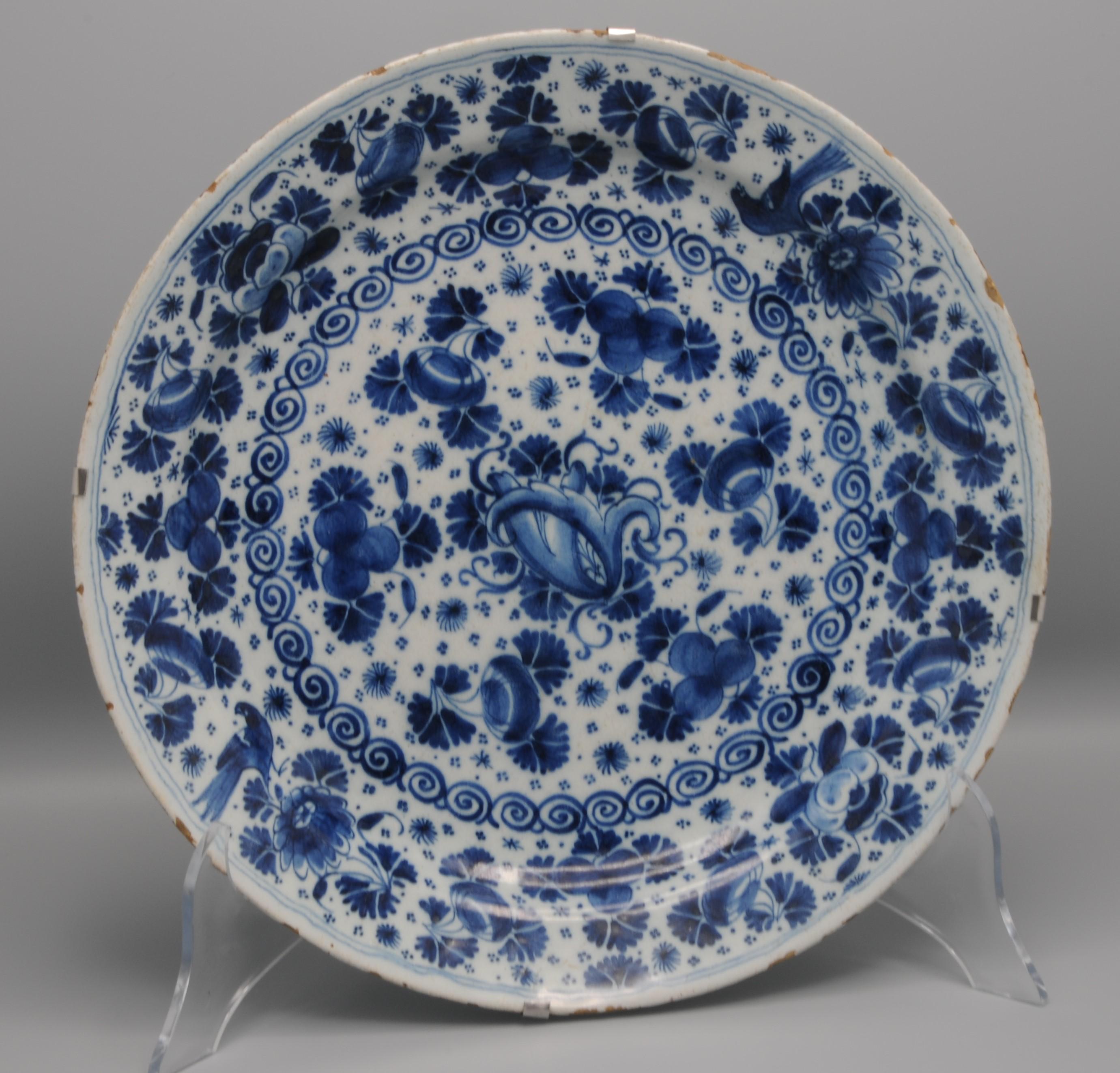 Early 18th century Blue Delftware dish with very crisp 'parsley or mille fleurs' decoration comprising sprays of flowers and birds.

Marked: Pieter Gerritsz. Kam, owner of Drie Posteleyne Astonne, 1700-1705
After his passing also used by  Widow