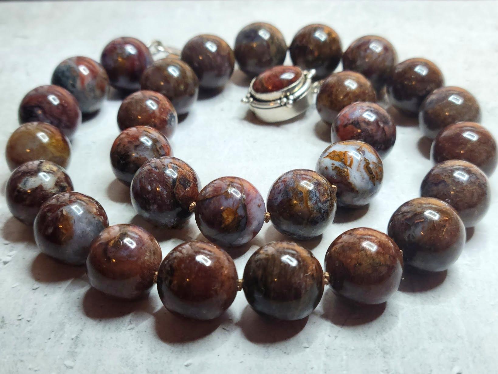Ce collier exquis est composé de pietersite naturelle, une pierre précieuse connue pour son énergie profonde et son jeu de couleurs unique. Le collier présente les caractéristiques suivantes :

Longueur : 19 pouces (environ 48 cm).
Taille des perles