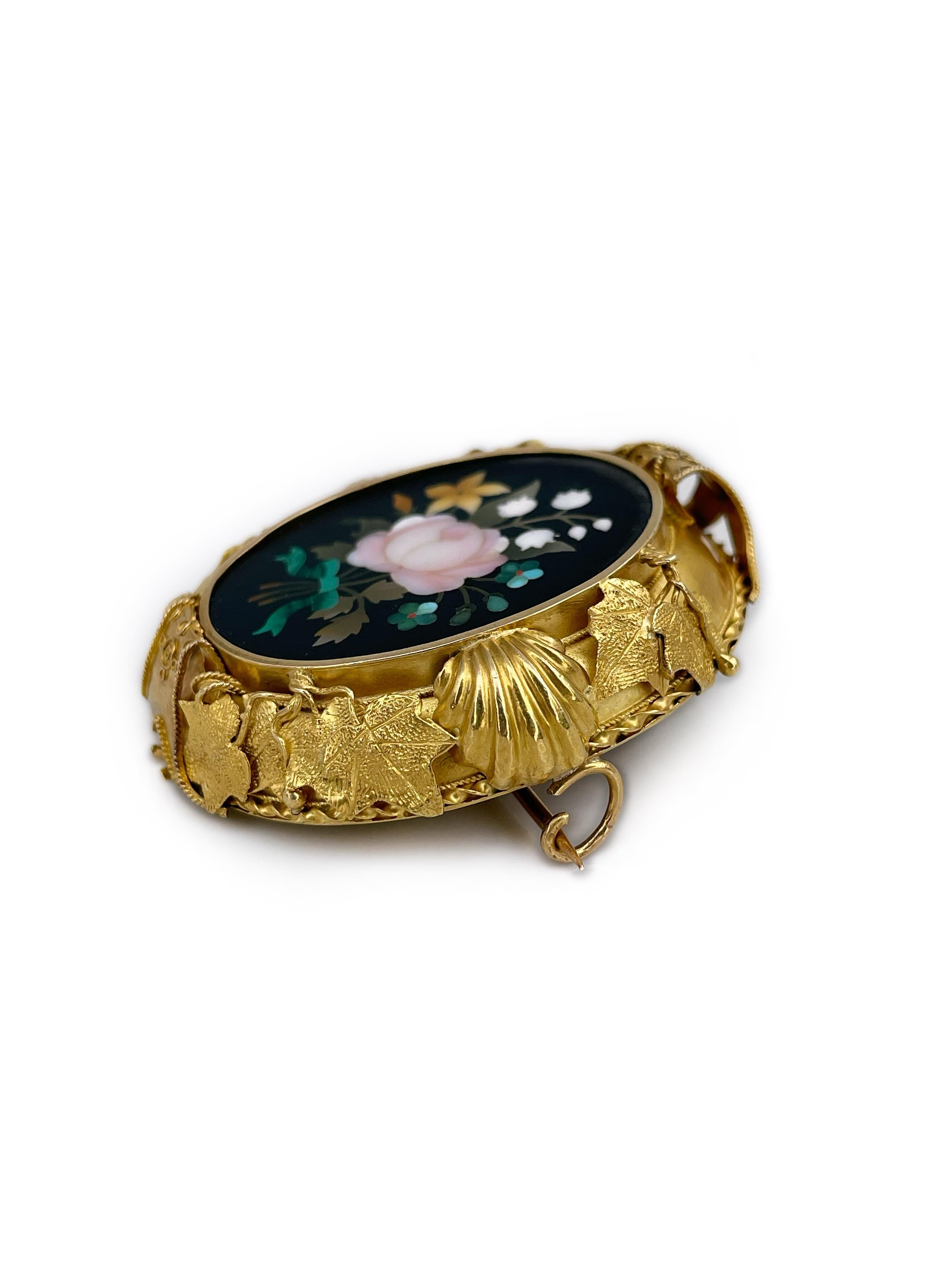 This is a lovely Victorian oval floral mosaic pin brooch crafted in 18K gold. The piece features semi precious stones cut and inlaid using Pietra dura mosaic technique. 

It has a very decorative frame. Unfortunately, one segment of the frame top is