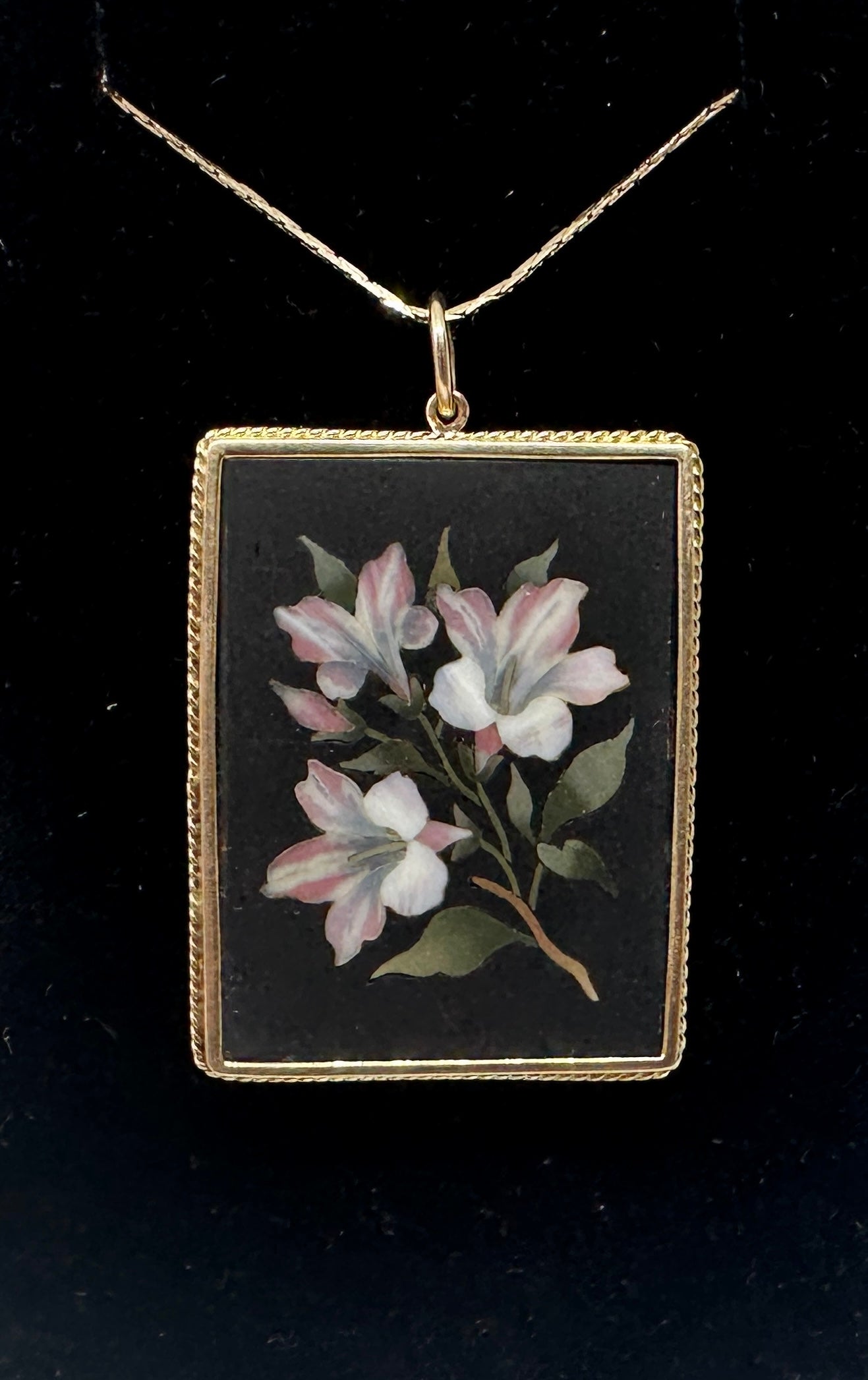 Lasciati conquistare da questo antico ciondolo in Pietra Dura di qualità museale in oro 14 carati con pietre semi-preziose intarsiate che creano un'immagine a mosaico di fiori di giglio.  Il ciondolo è un capolavoro della lavorazione della Pietra