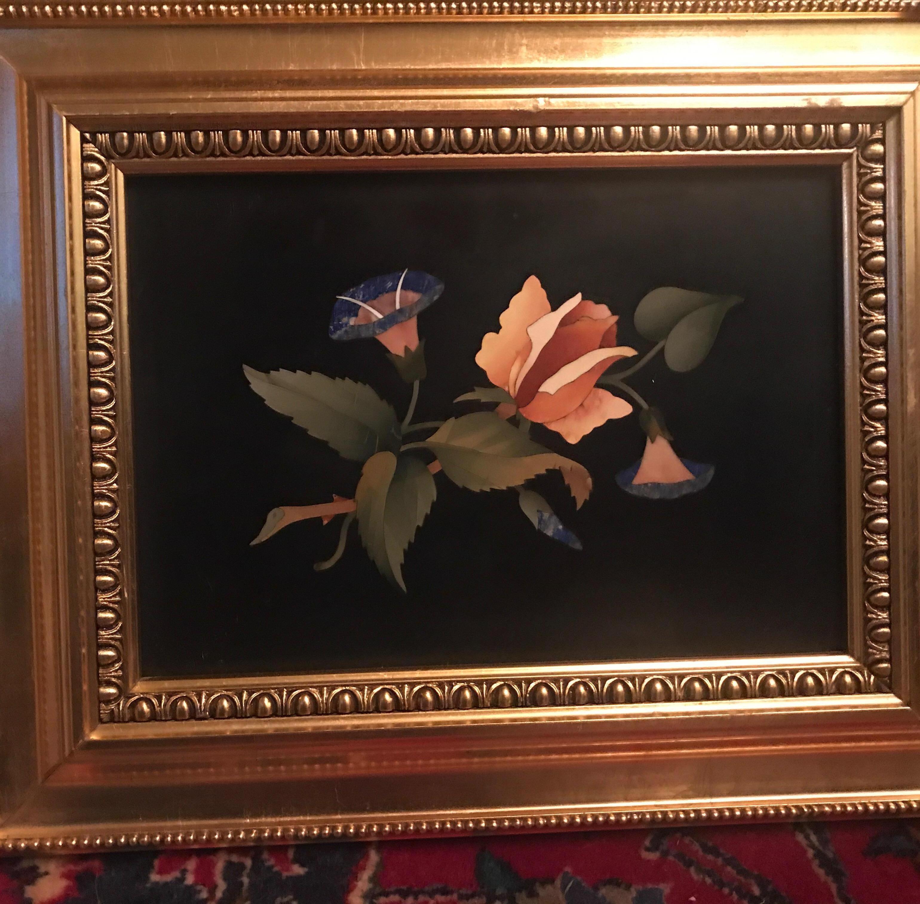 An Italian stone Pietra Dura plague is gold leaf frame, early 20th century, signed on back. The Belgian slated background with Lapiz and other silica based stones hand cut and fitted into a floral center. 
Pietra dura is a term for the inlay