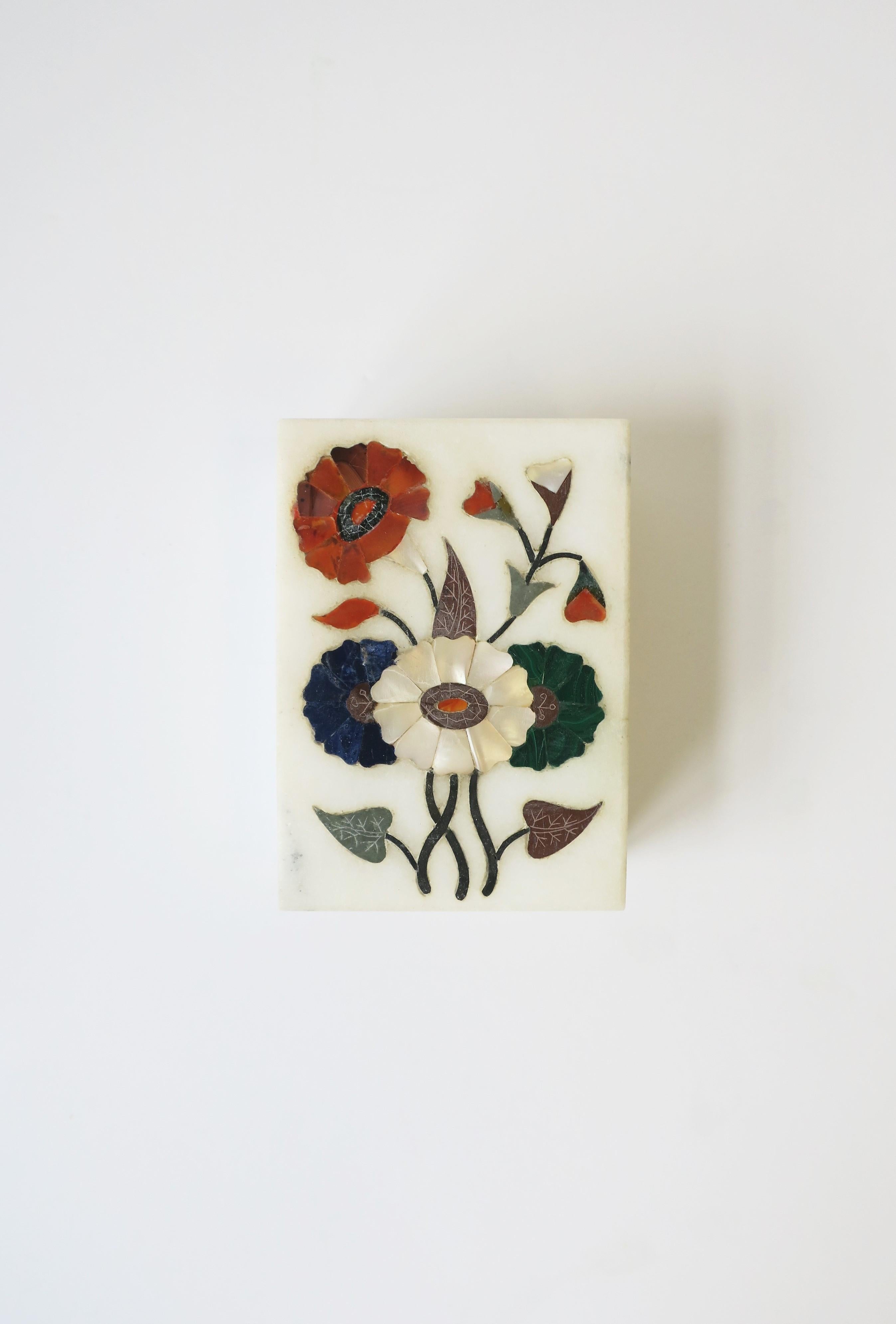 A beautiful multi semi-preciouses stone floral inlay or 'pietra dura' design box, circa 20th century. Box cover includes red carnelian, blue lapis, green malachite, white mother of pearl and other stones. Box itself is made from white granite