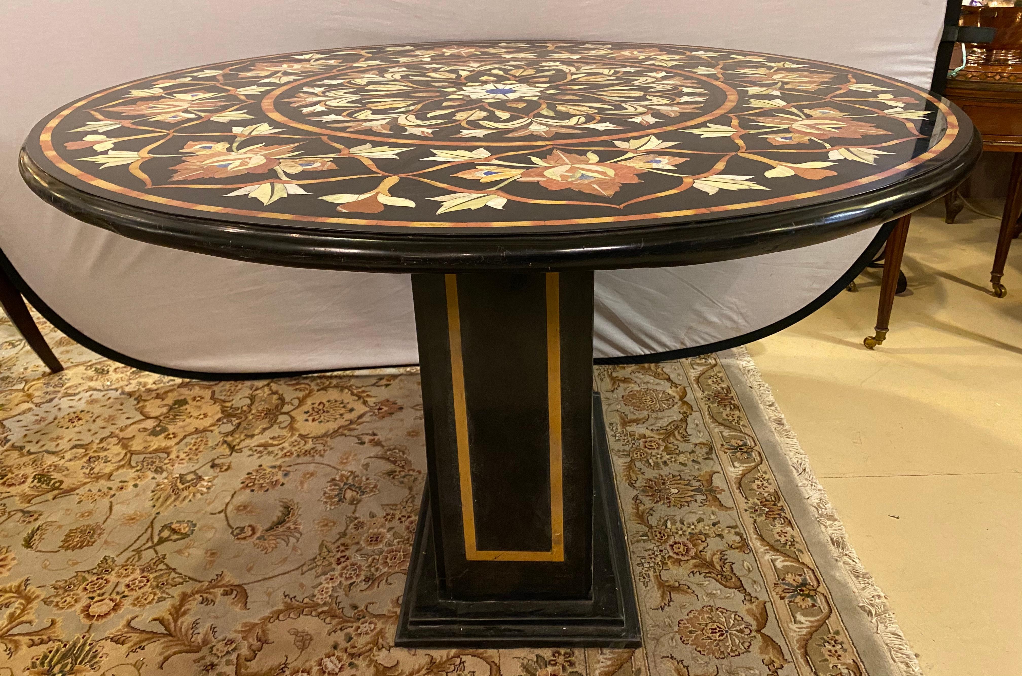 Pietra Dura marble top dining or center table with marble ebony inlaid pedestal base.The finely cut and inlaid marble tabletop is 1.5 inches thick with rounded edges and is 48 inches in diameter. This stunning center or dining table is one of two