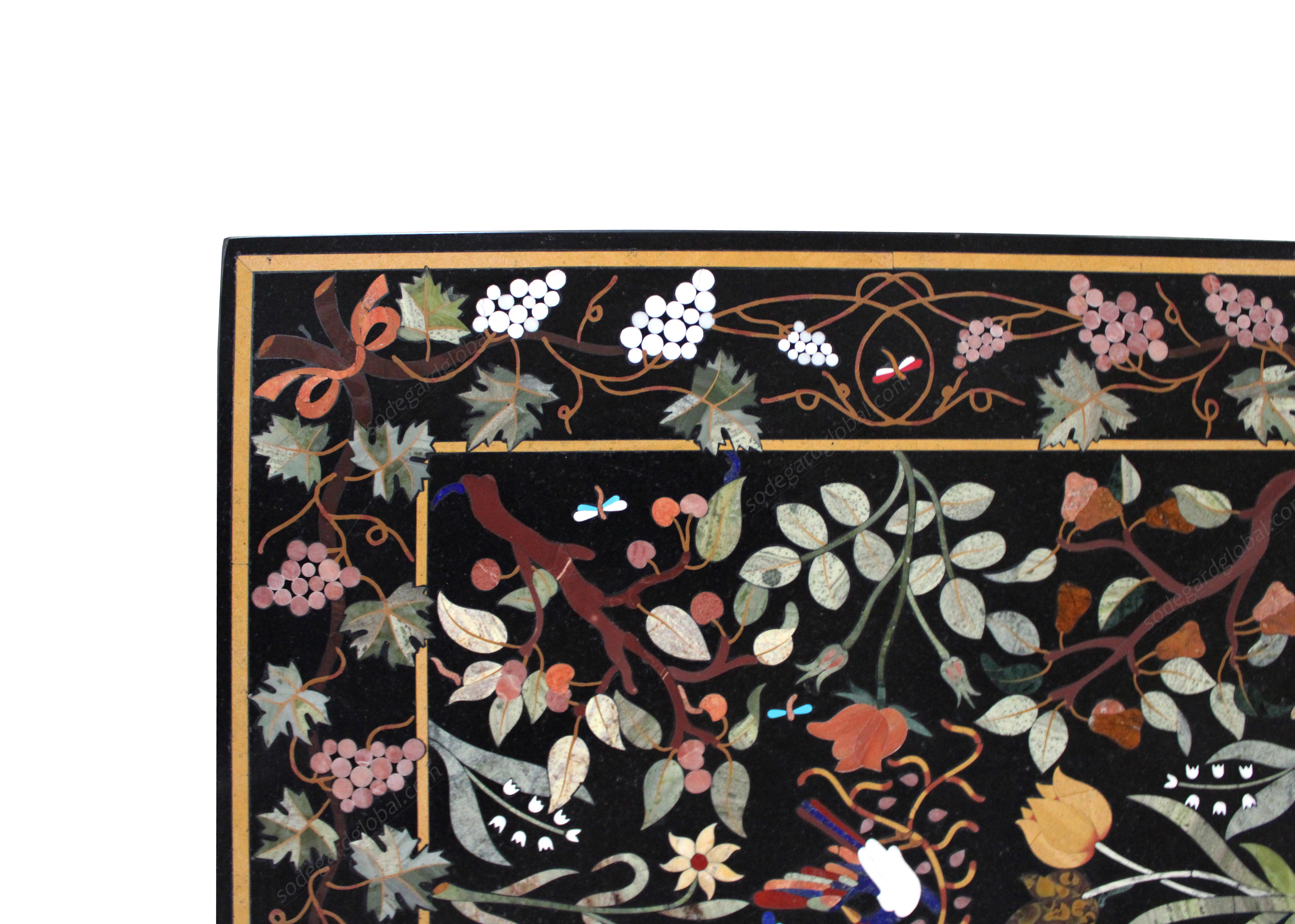 This stunning coffee table top exhibits one of the most intricate Italian Pietra Dura design. The rich compositaion uses more than 20 different semi-precious stones inlaid over the black marble back ground using the centuries old techniques of